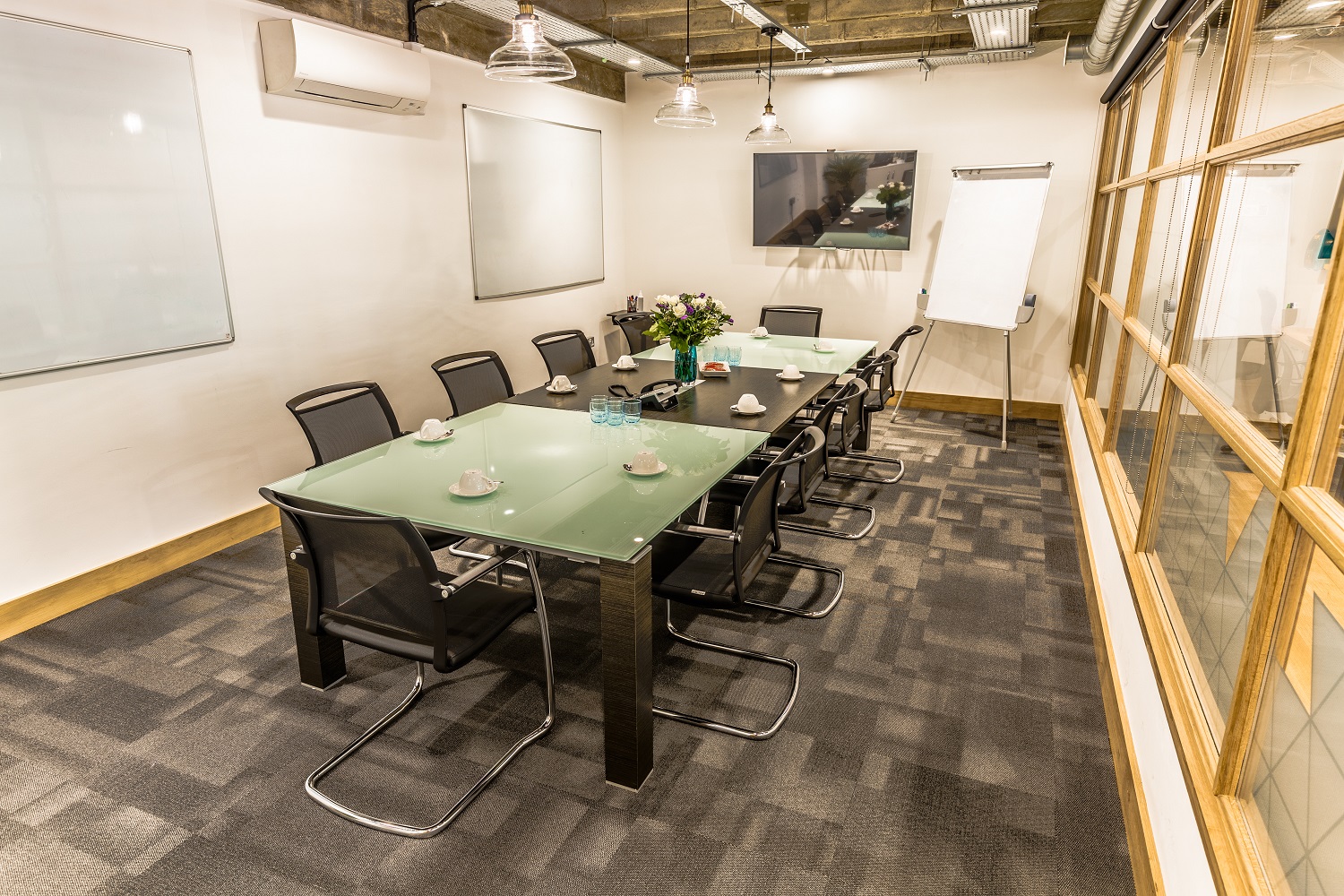 Modern conference room with glass table, ideal for meetings and presentations.