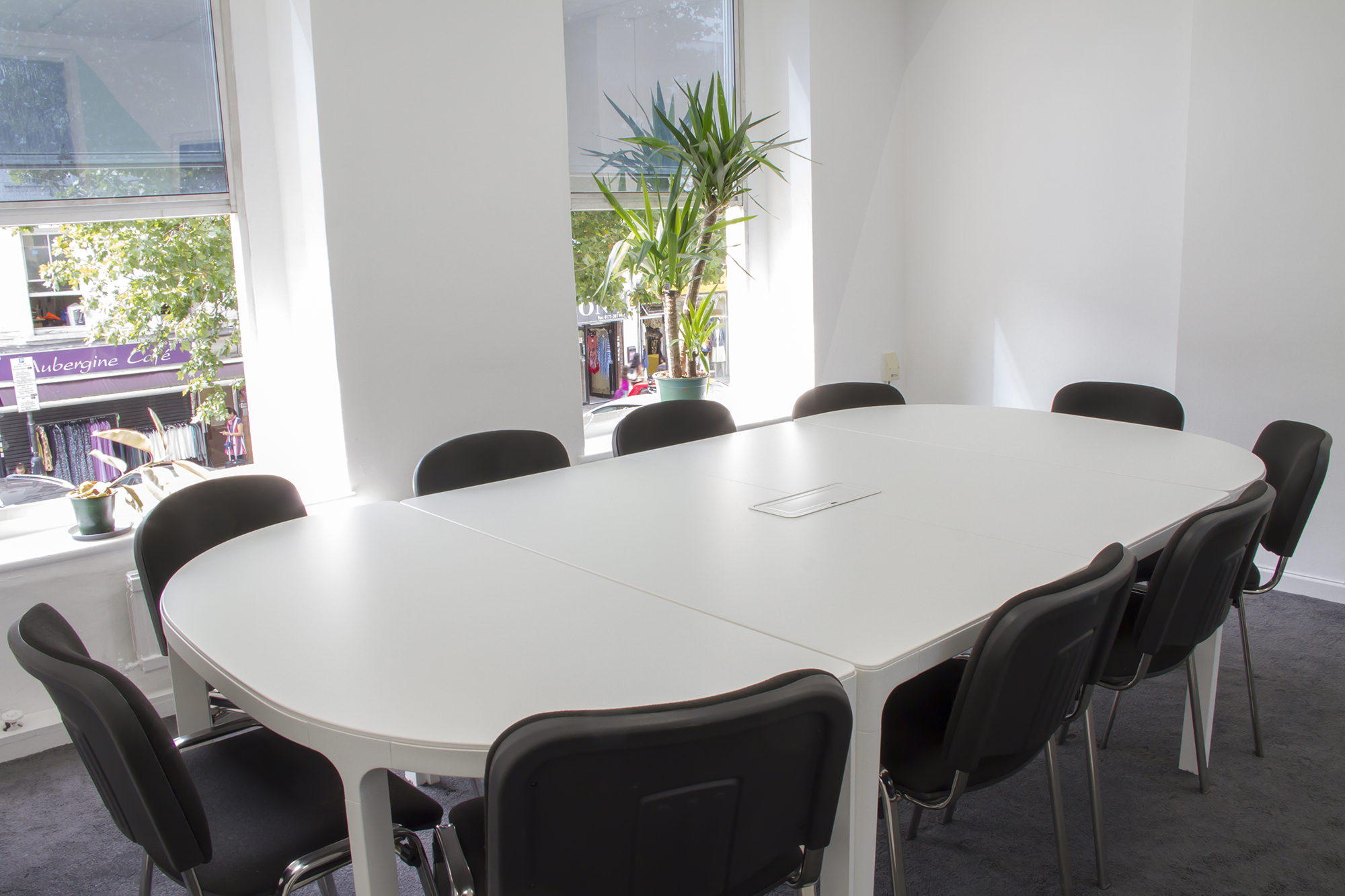 Modern meeting room with oval table, ideal for events and workshops.