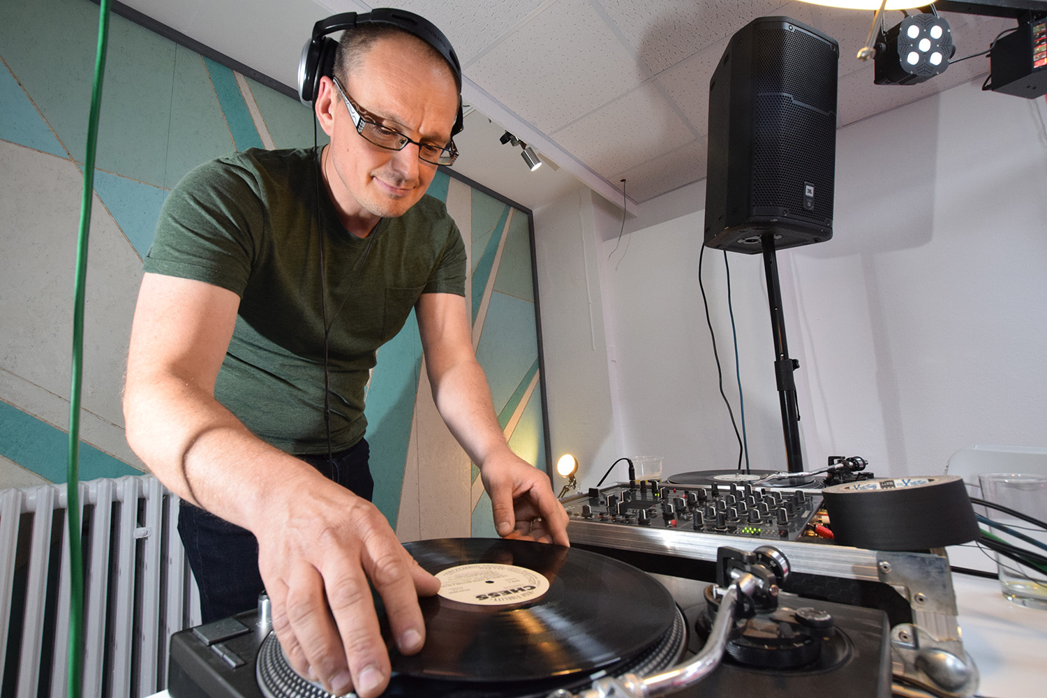DJ mixing vinyl records at Space4 Events, enhancing networking and entertainment.