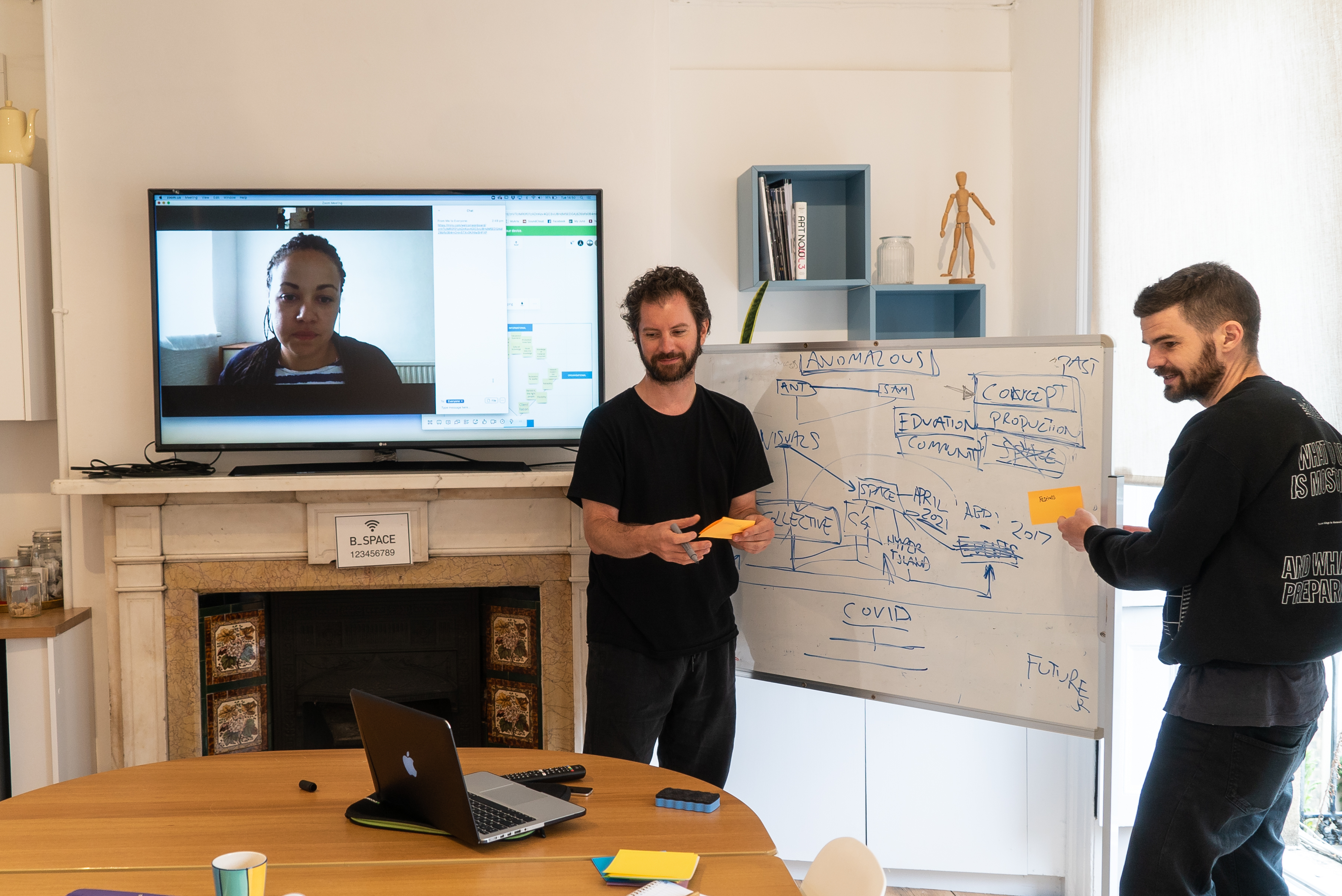 Hybrid meeting setup in The Office, featuring a whiteboard and remote participant.