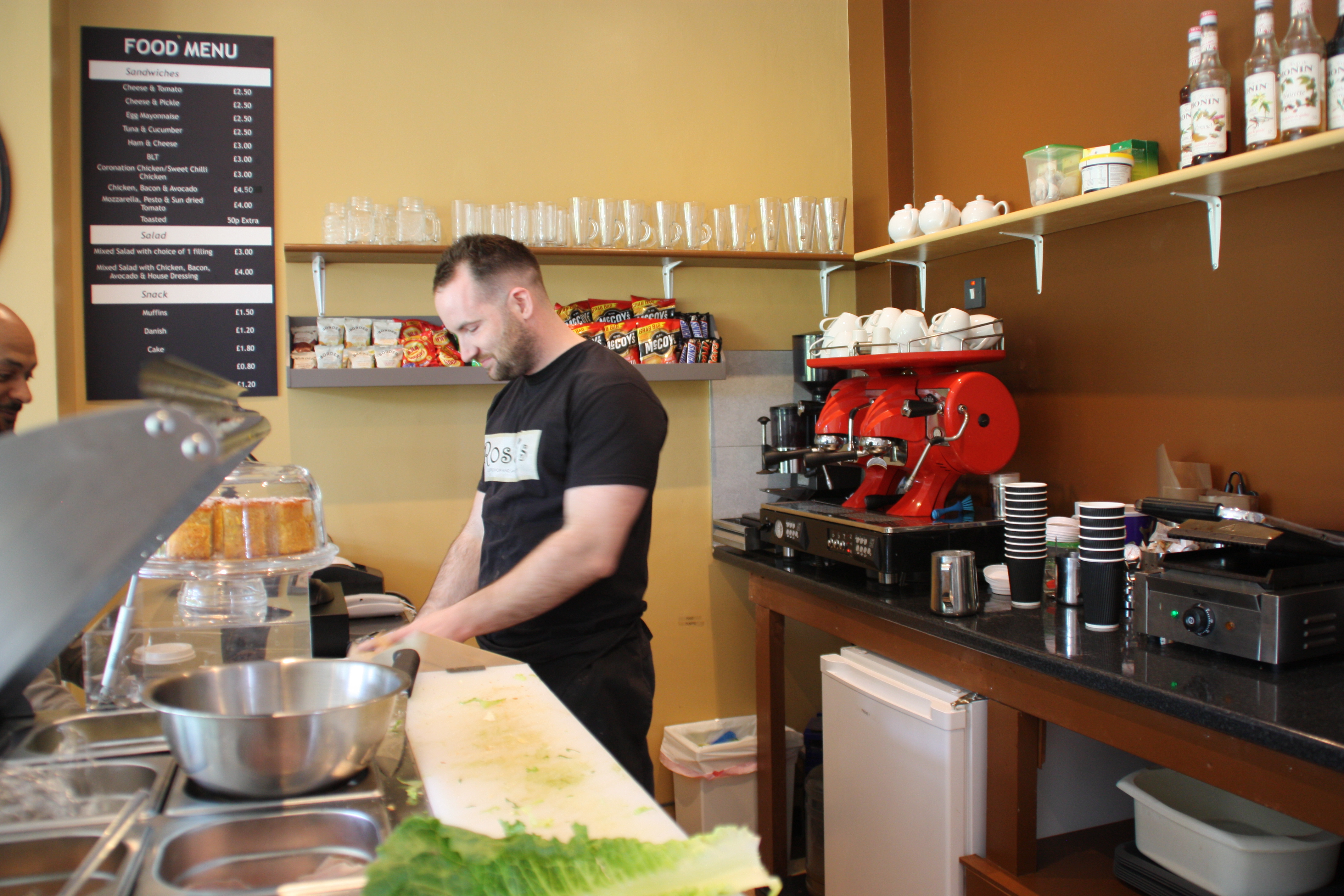 Bustling Rossi's Coffee Shop with barista preparing drinks for networking events.
