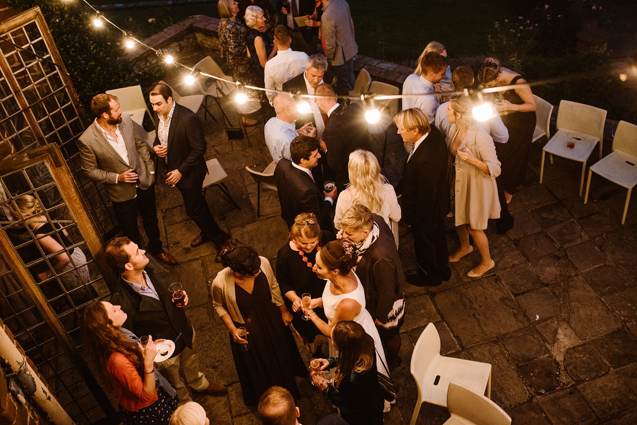 Vibrant outdoor networking event in Voewood gardens under string lights.