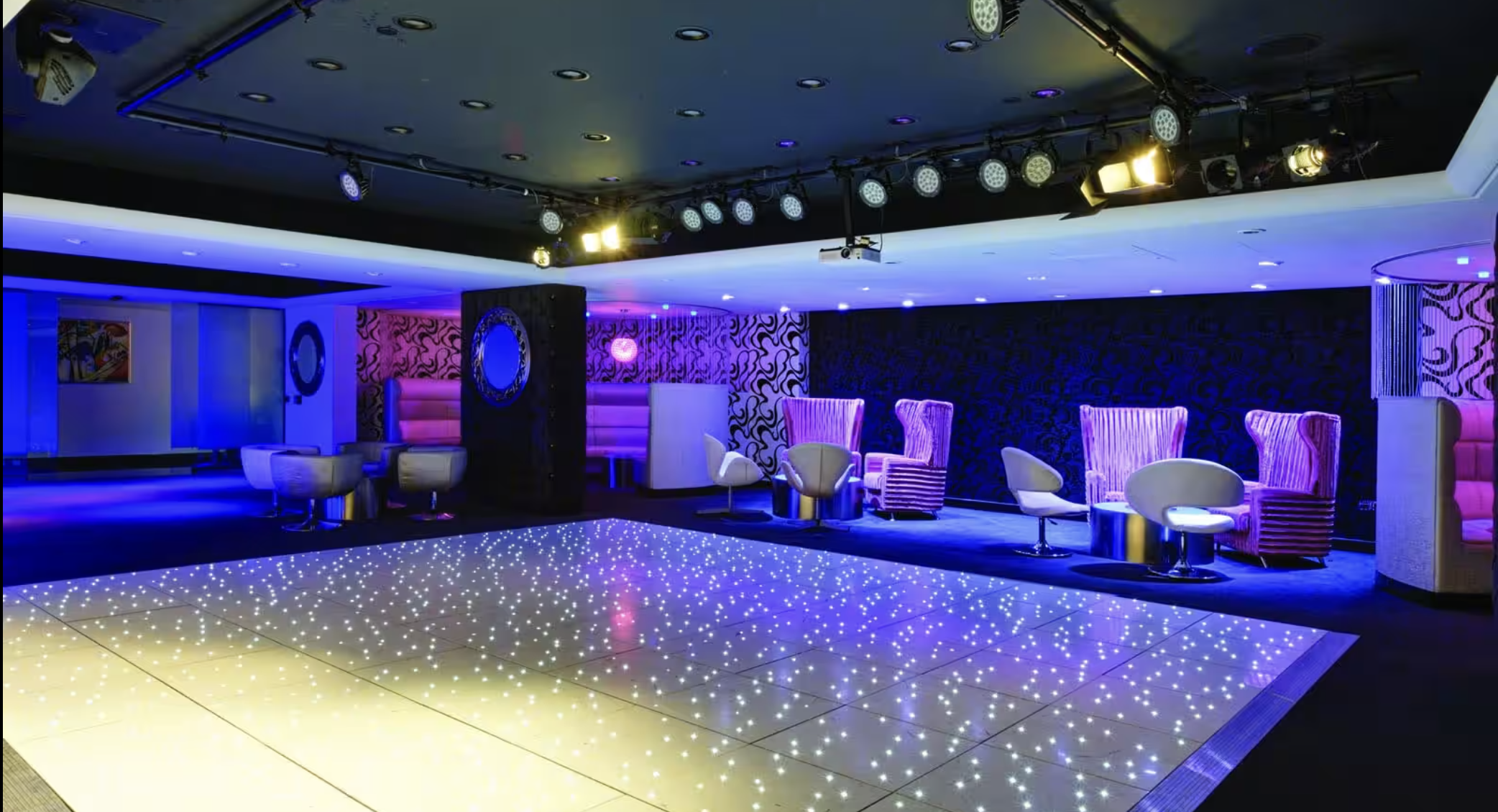 Stylish event space at Club X, featuring a sleek dance floor and vibrant lighting.