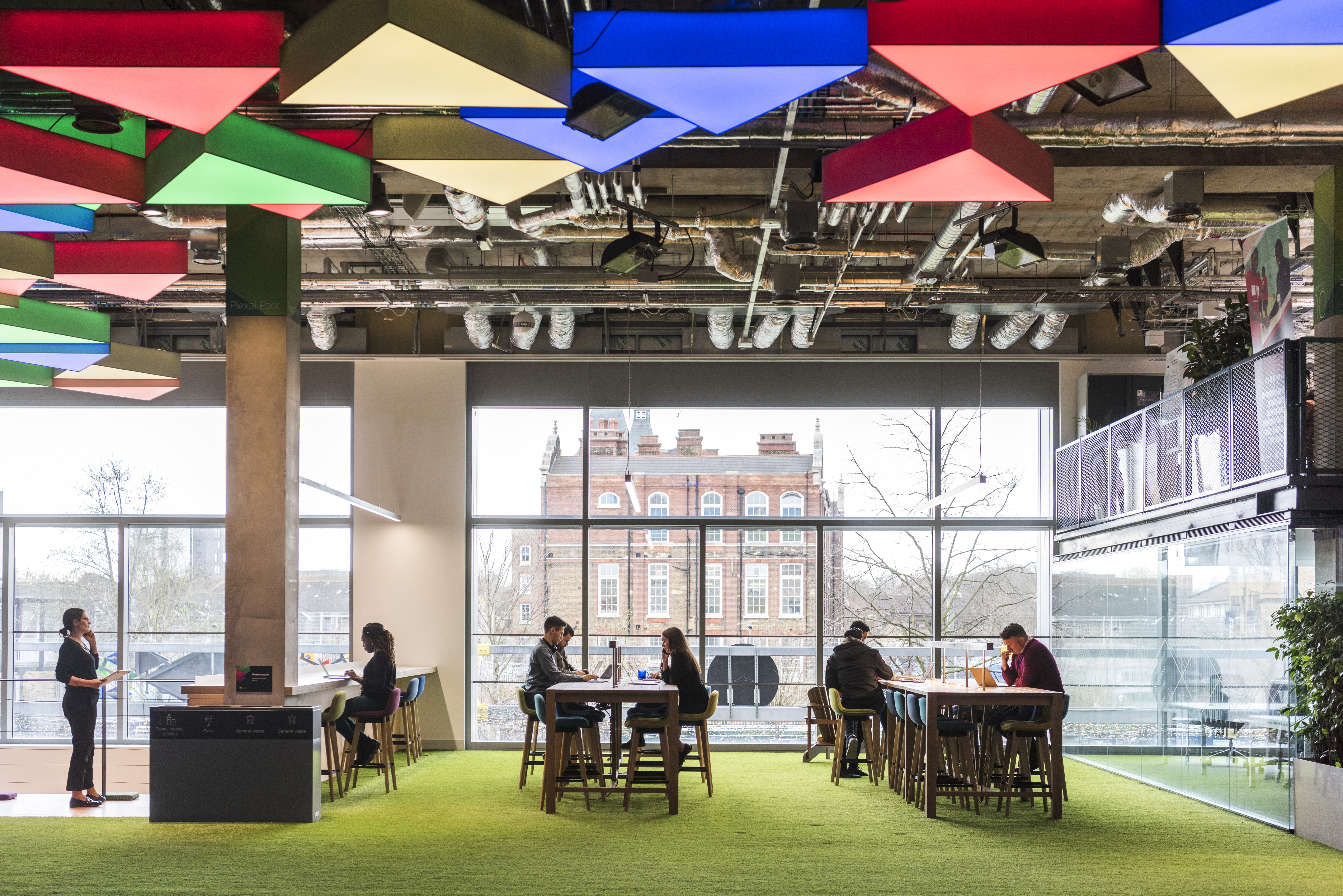 Modern flexible workspace with vibrant ceiling, ideal for meetings and gatherings.