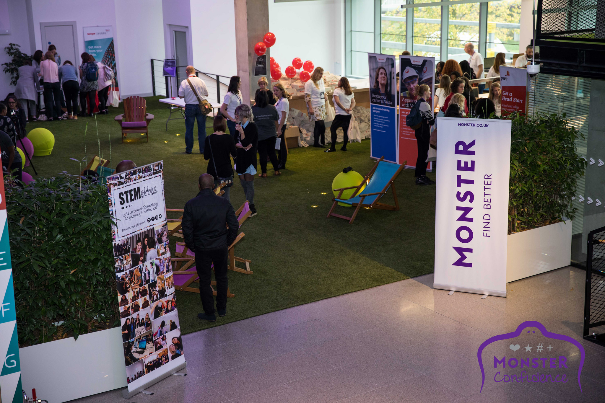 Vibrant networking event space with green carpet and lounge seating at Plexal.