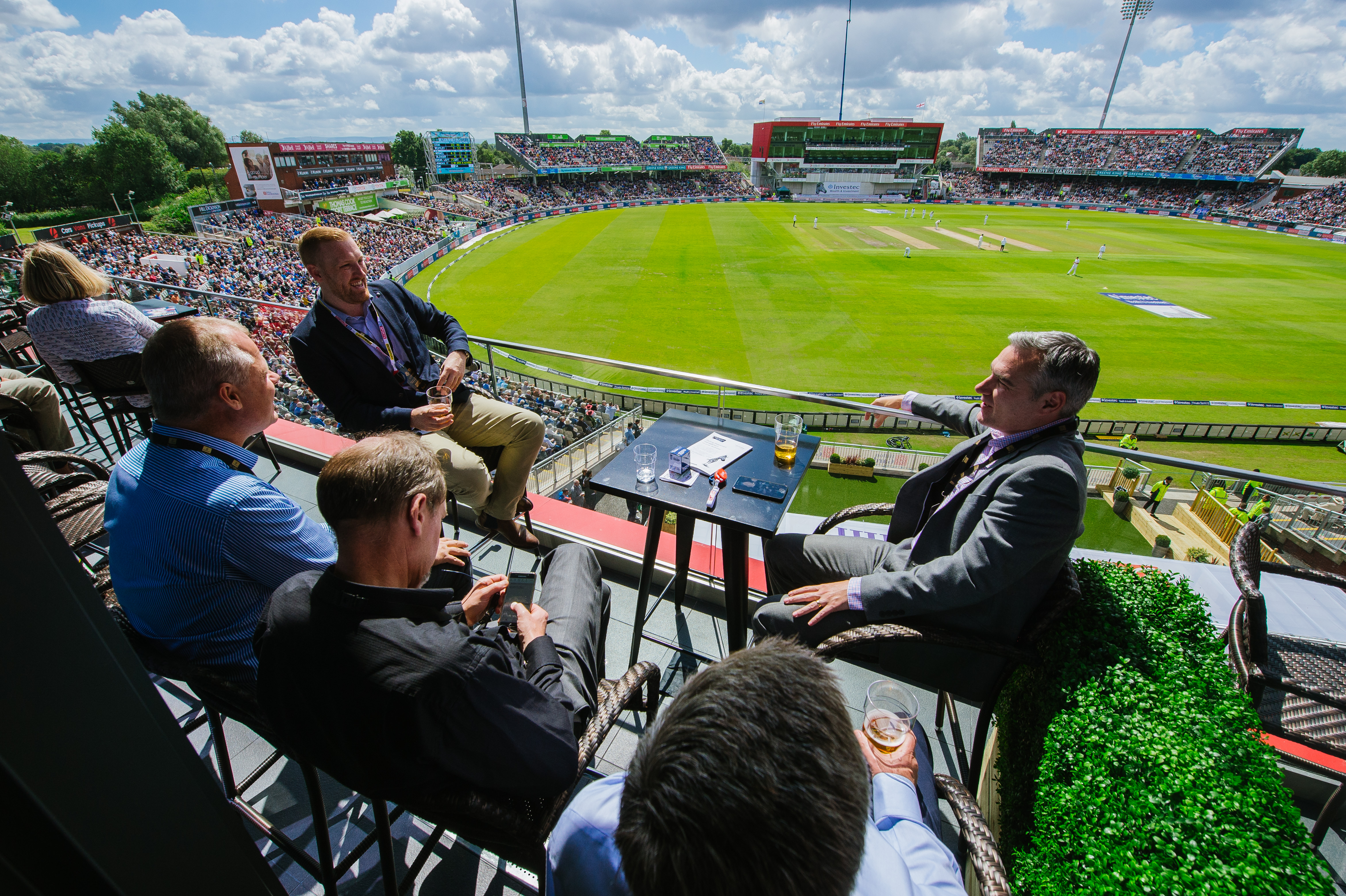 Outdoor networking event at Hilton Garden Inn Manchester, featuring a lively cricket stadium crowd.