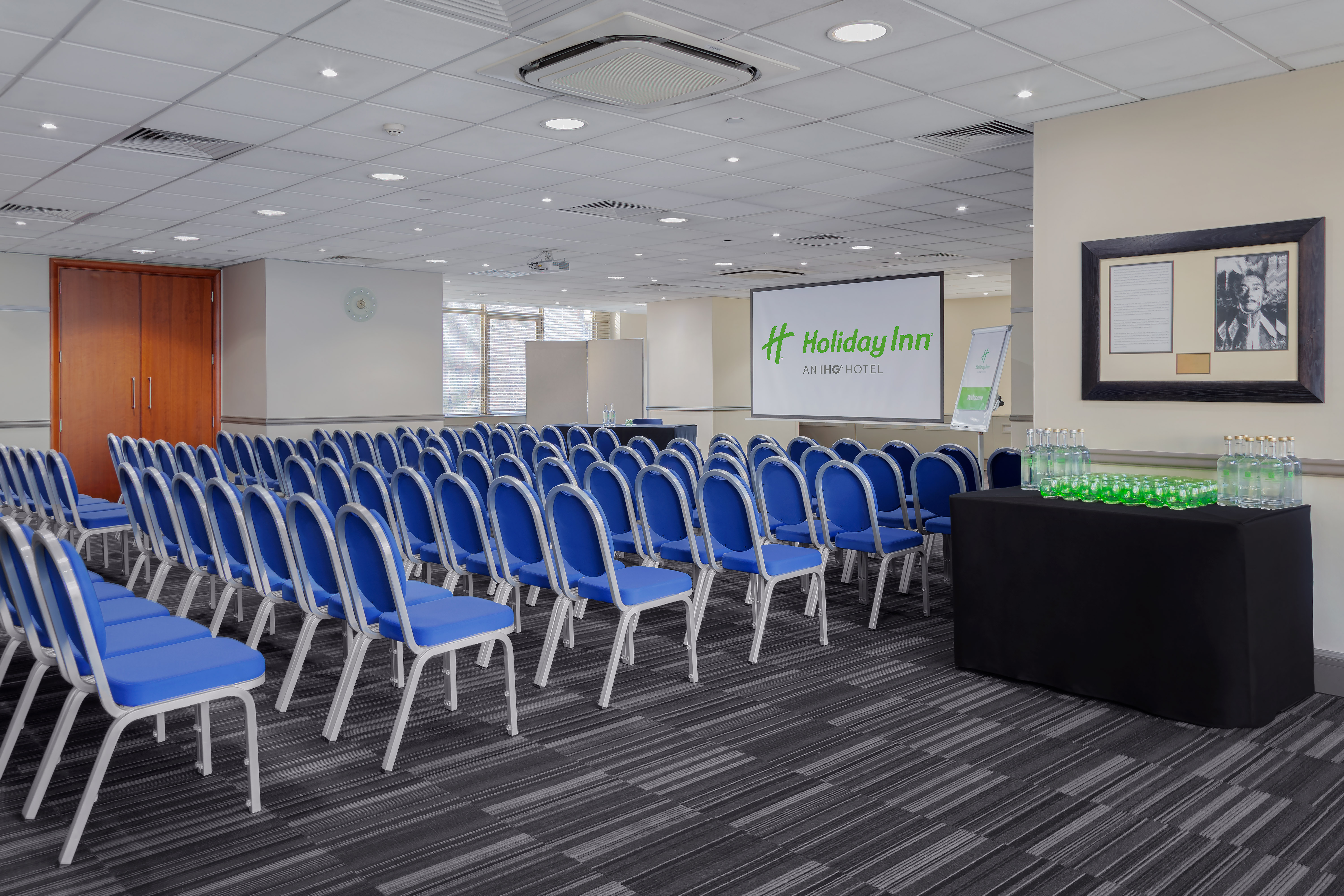 Meeting space with blue chairs at Holiday Inn London Kensington for conferences.