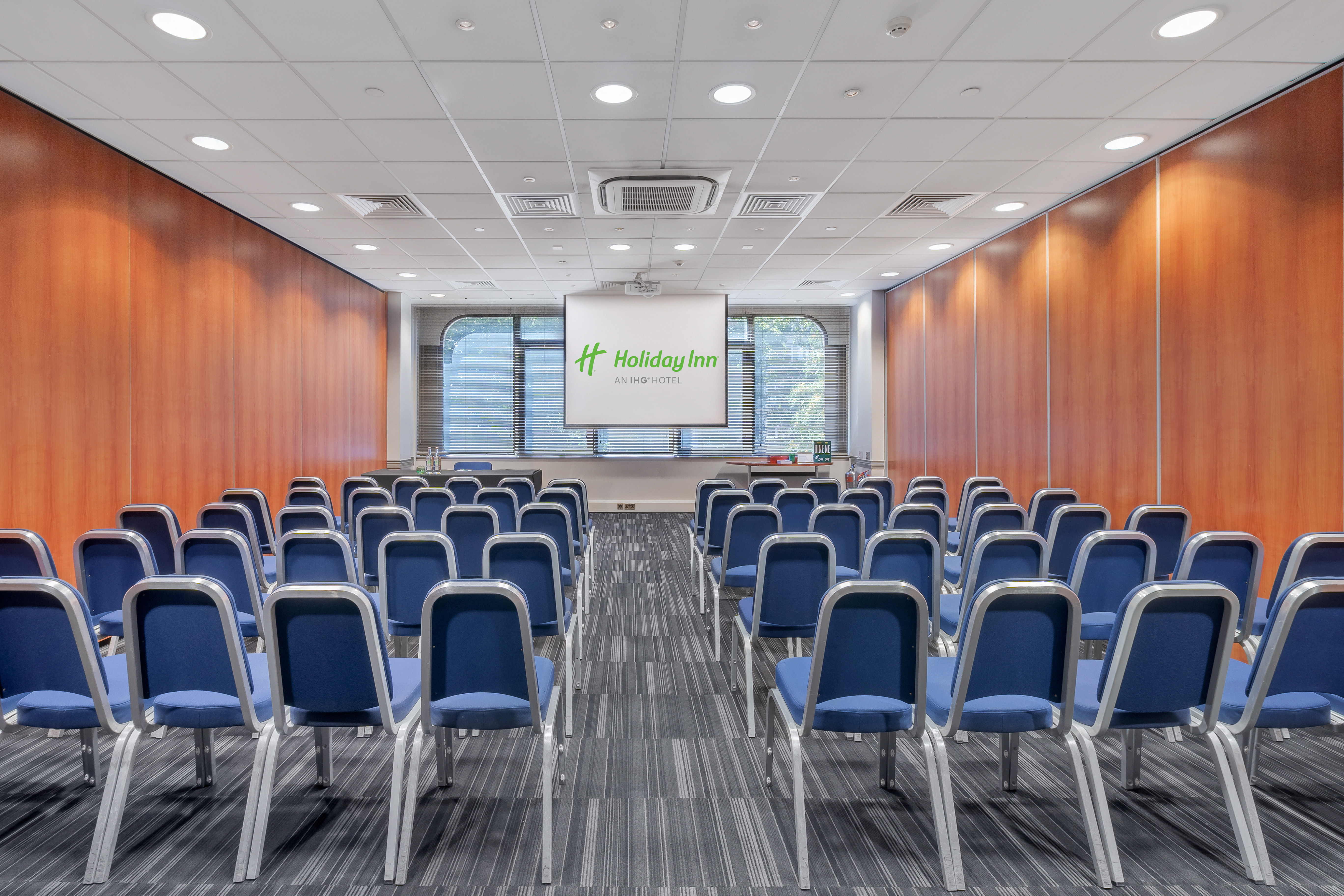 Meeting room at Holiday Inn Kensington with blue chairs for corporate events.