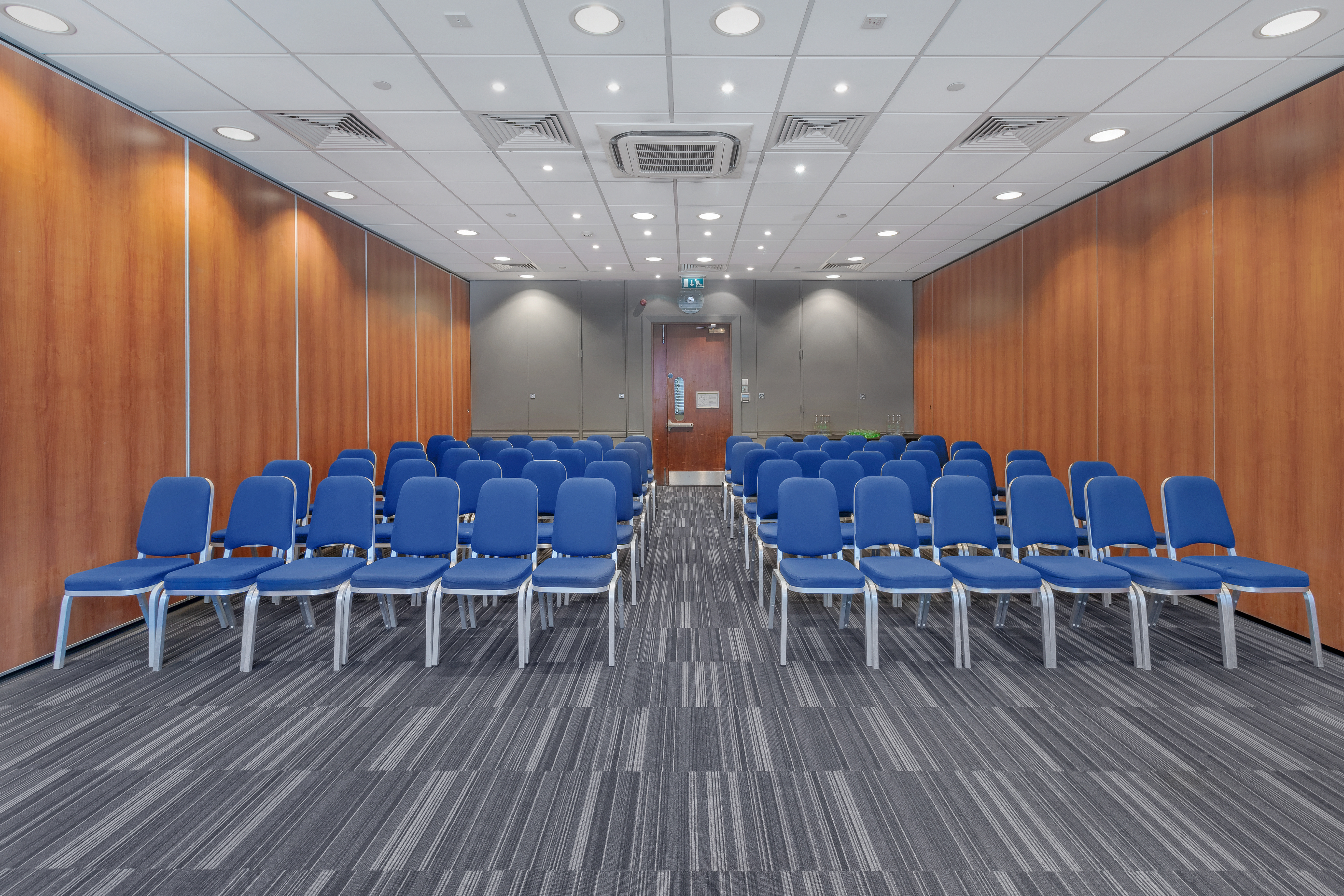Meeting room with blue chairs at Holiday Inn London Kensington for workshops and presentations.