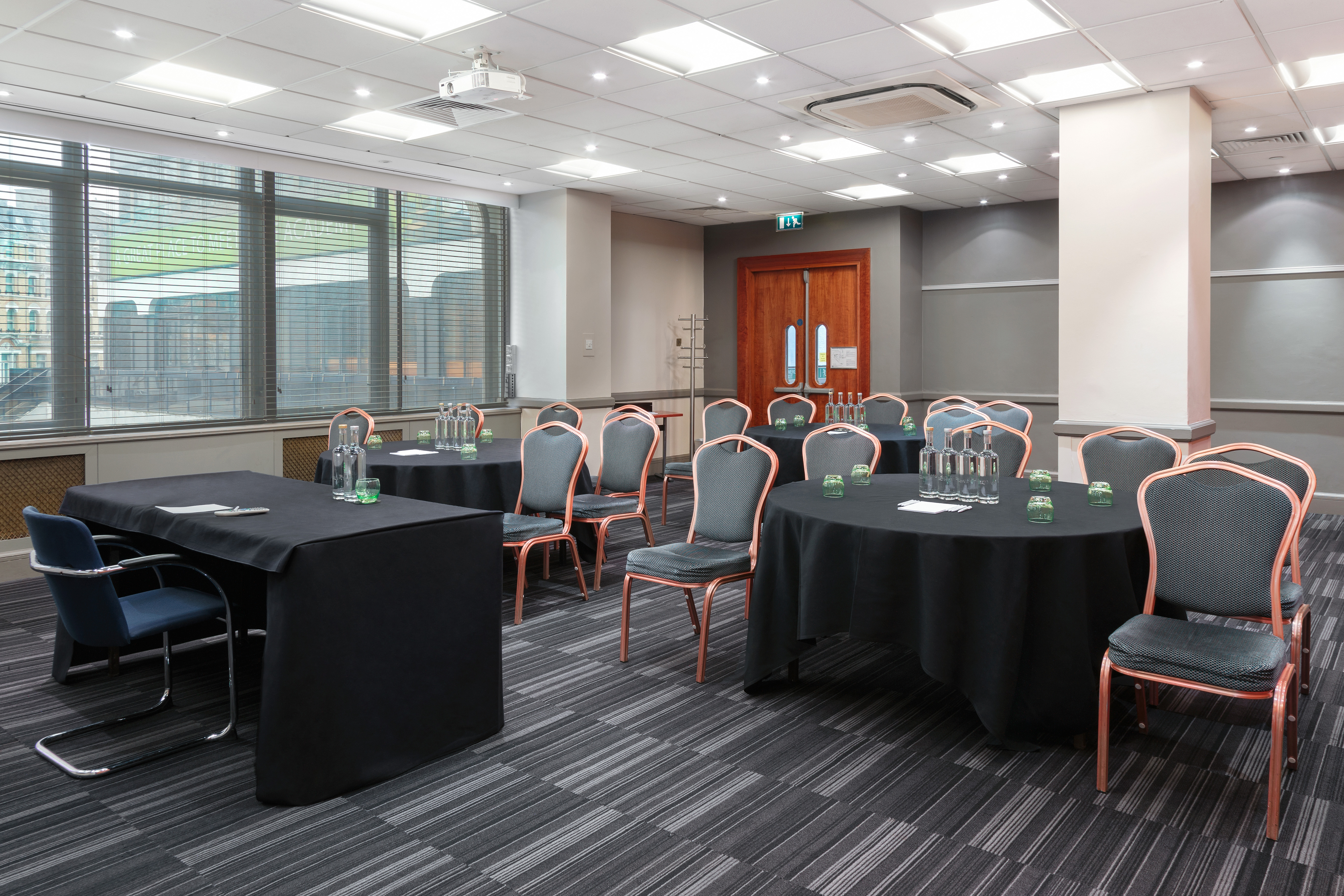 Hockney in a meeting room with round tables, ideal for events and presentations.