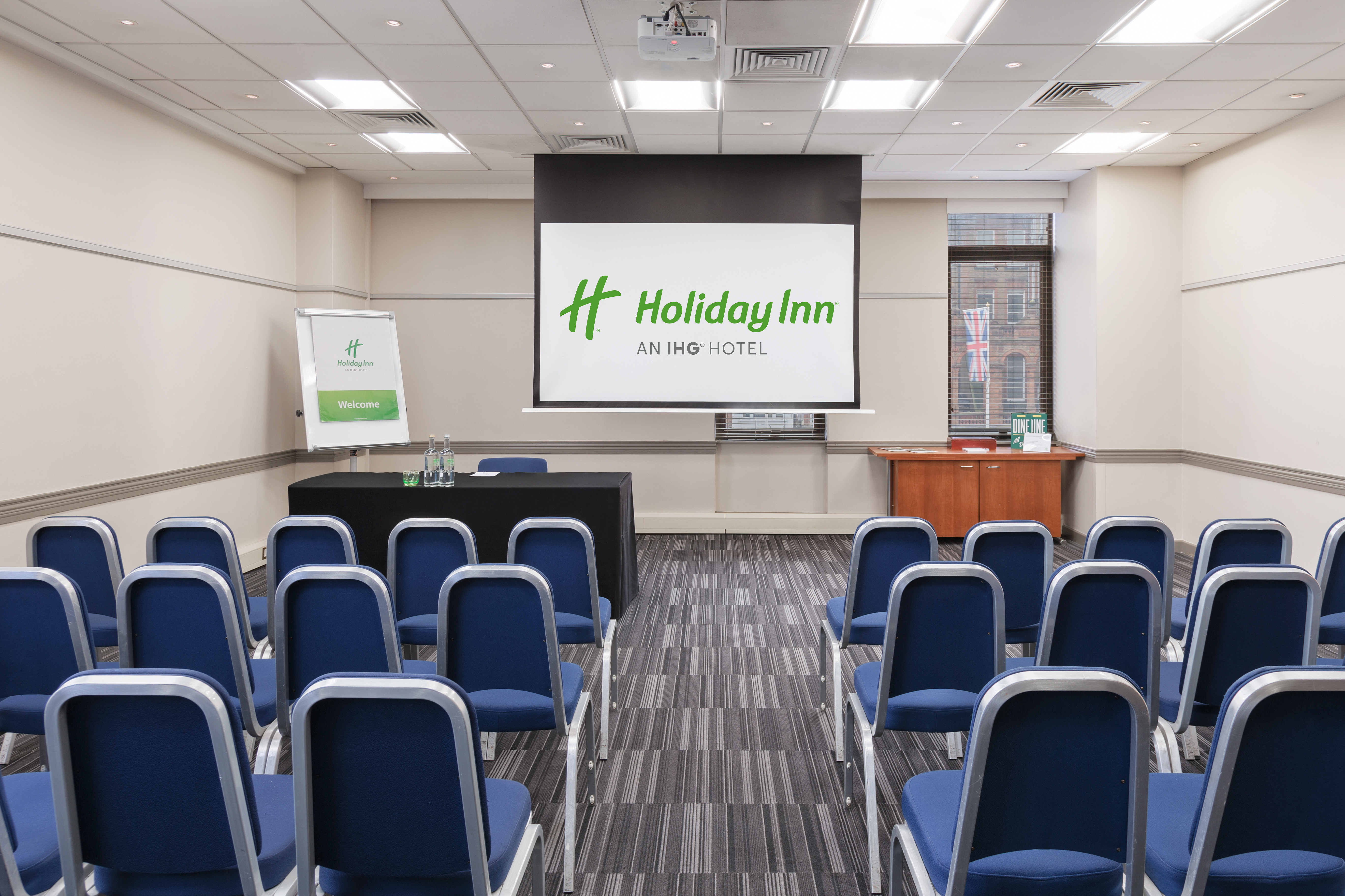Meeting room at Holiday Inn London Kensington Forum with clear presentation screen.