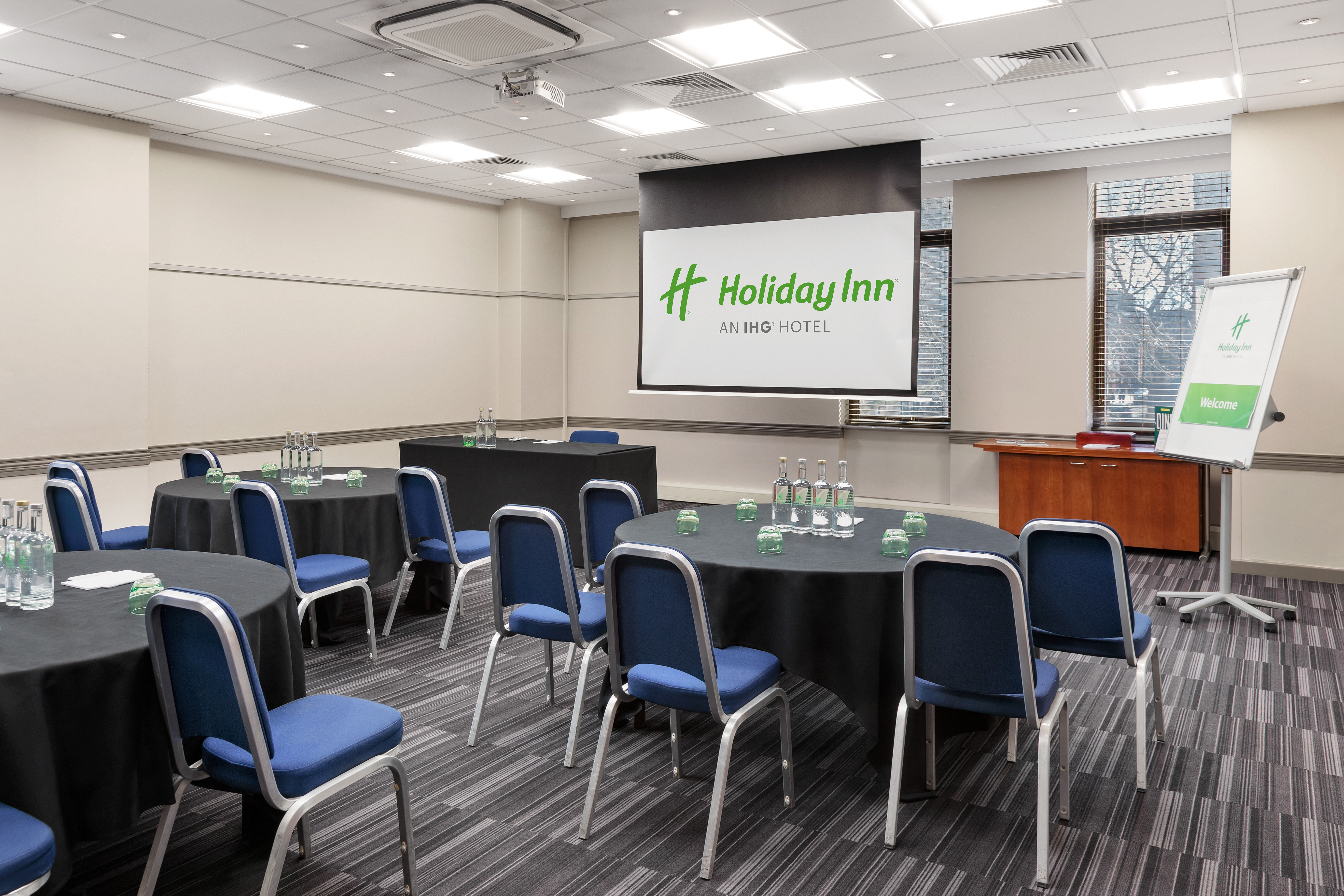 Meeting room at Holiday Inn Kensington with round tables for corporate events.