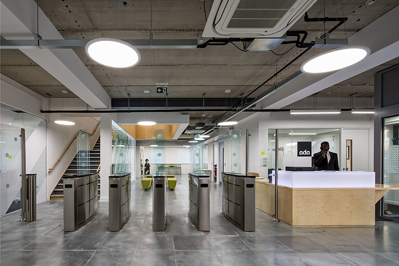 Modern reception area with glass barriers at Ada National College for corporate events.