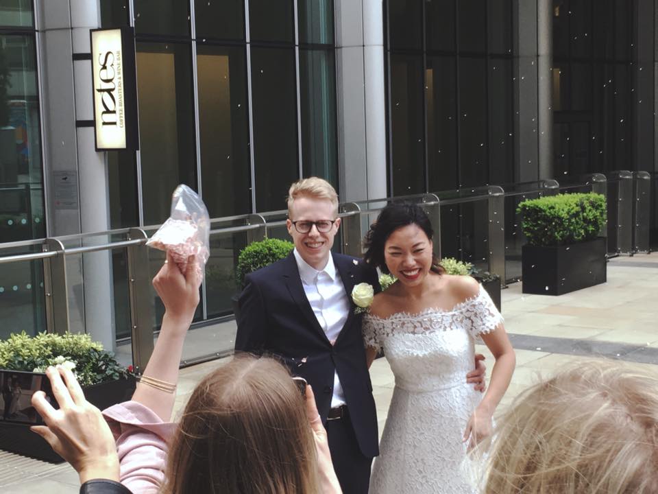 Joyful couple celebrating wedding in modern urban venue with engaged guests.