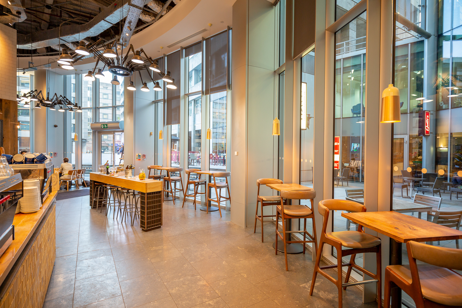 Modern café venue with large windows, perfect for networking events and informal meetings.