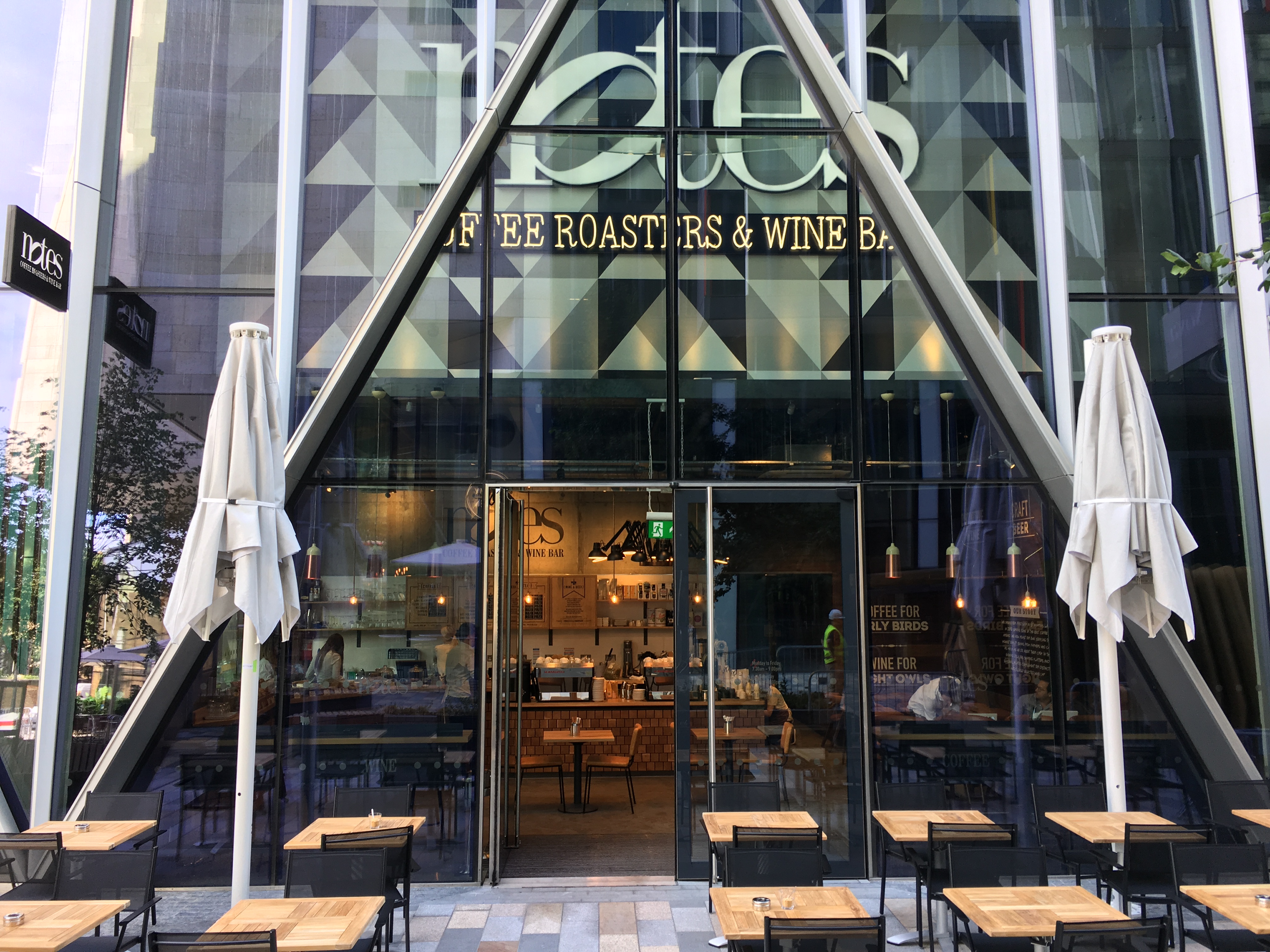 Modern café with glass façade, ideal for networking events and casual gatherings.
