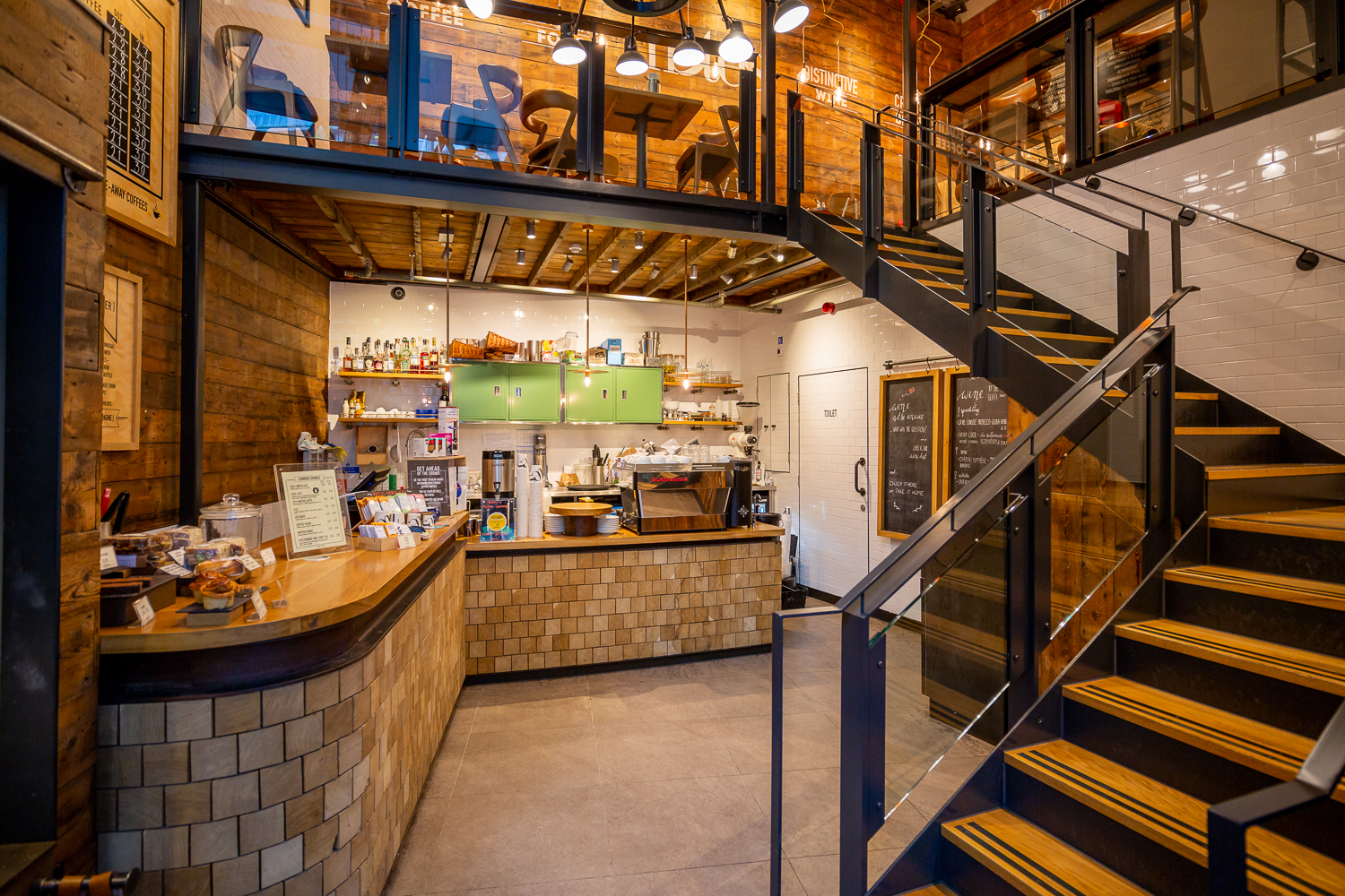 Stylish multi-level event venue with modern barista counter and warm decor.