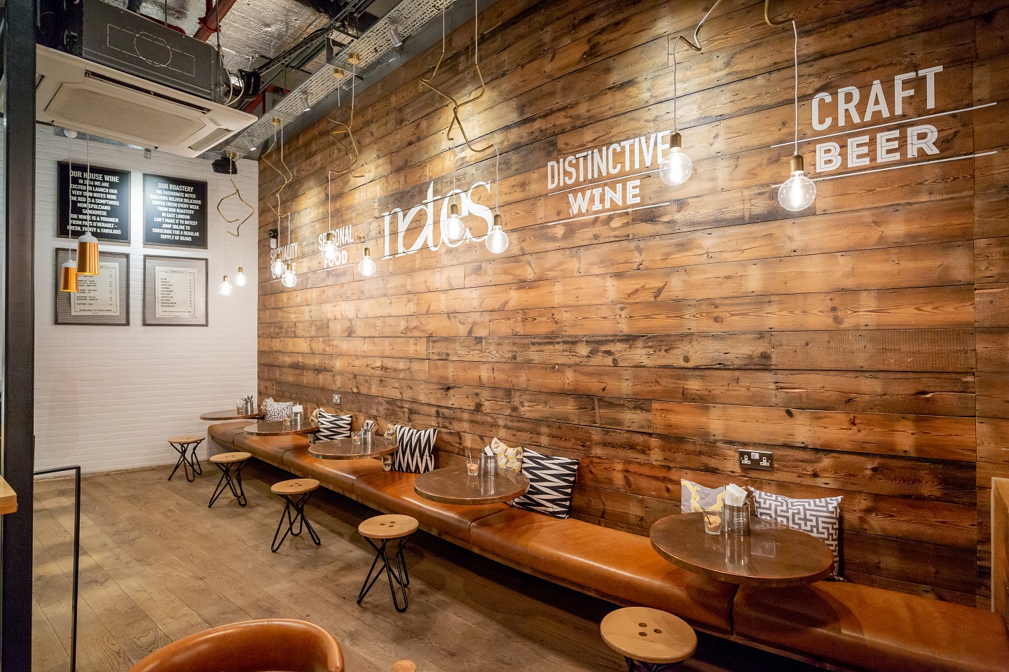 Stylish venue with rustic wooden wall, ideal for intimate gatherings and networking events.