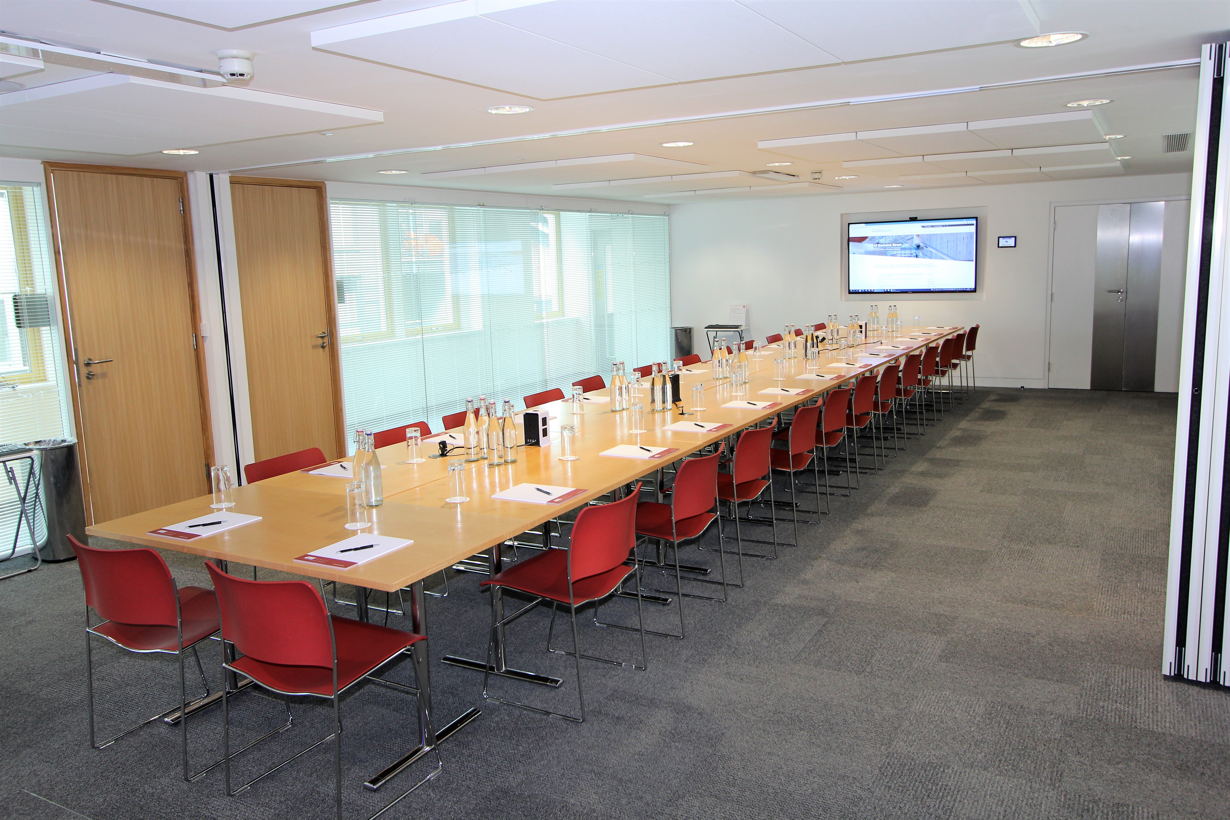 Modern meeting room with glass walls, ideal for professional gatherings and presentations.