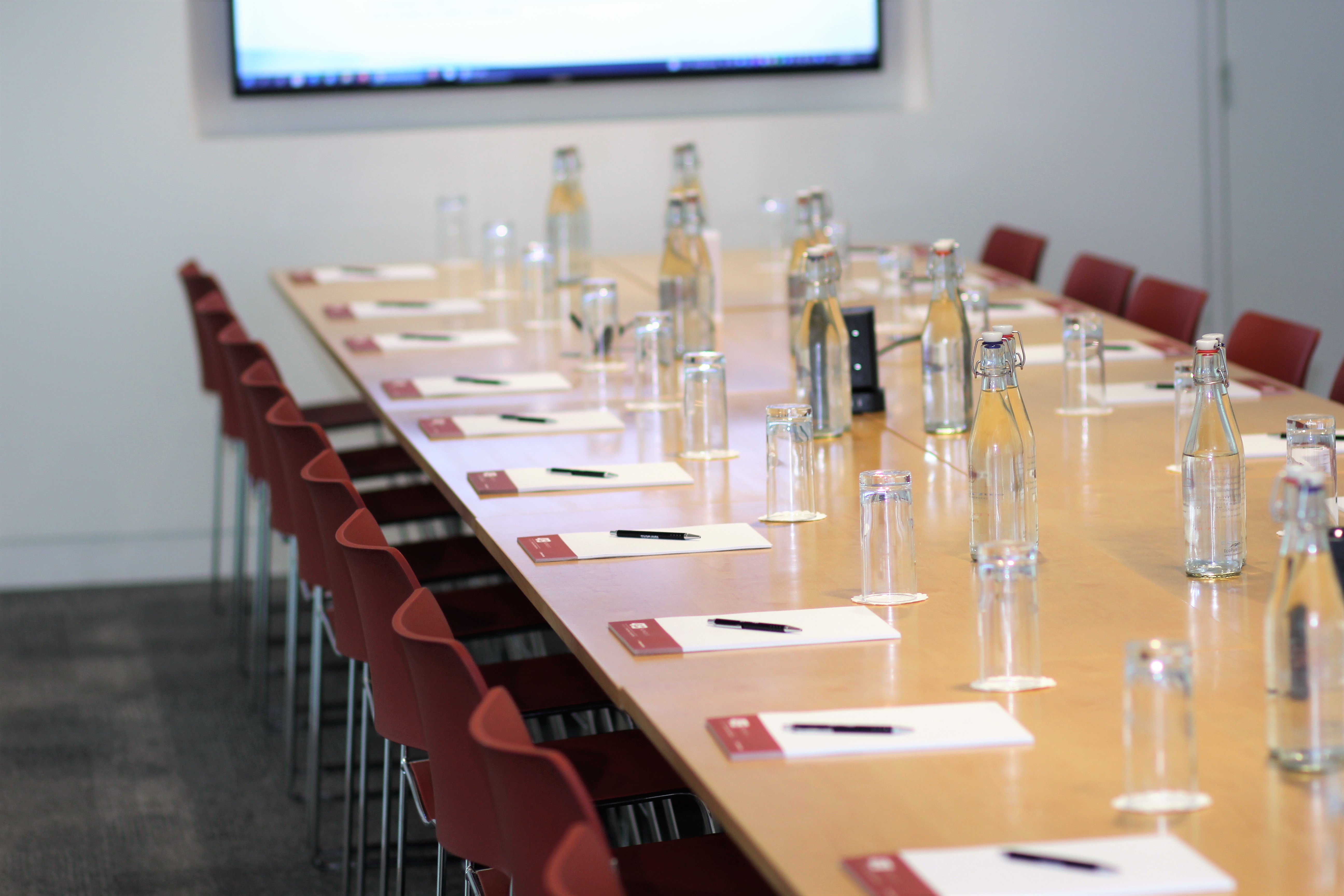 Bastwick Suite meeting room with long table, notepads, and presentation screen for events.