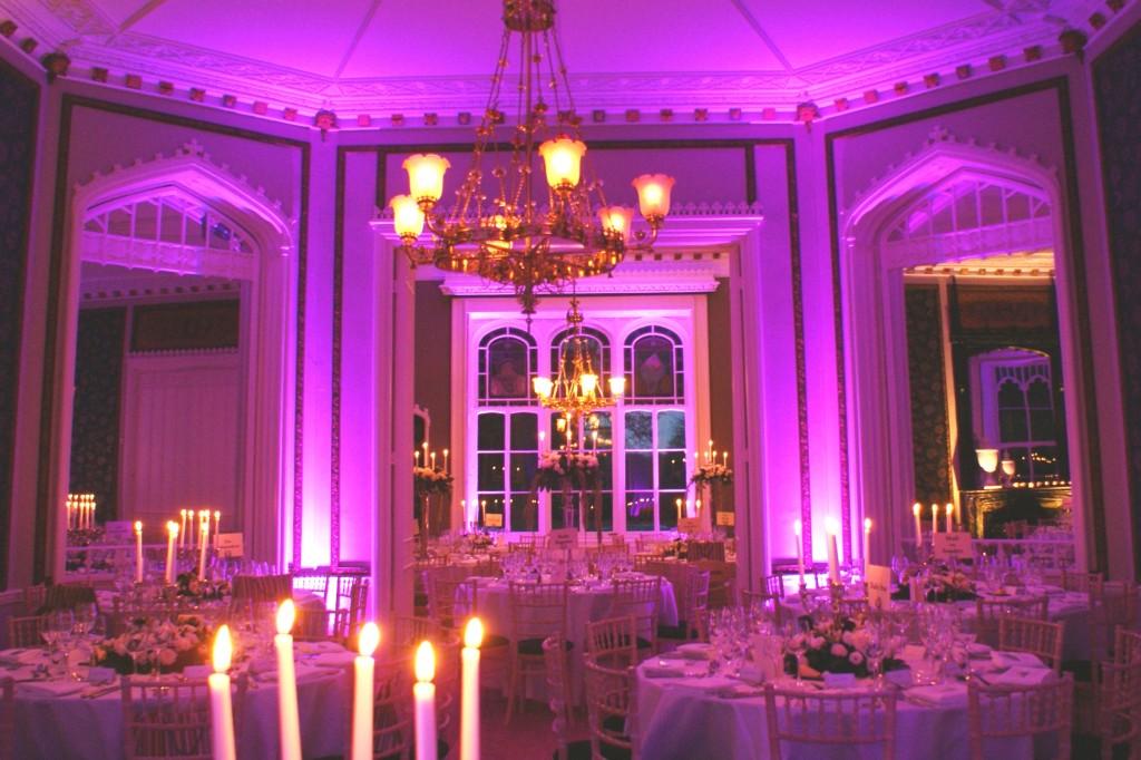 Elegant event space at Nonsuch Mansion with round tables and ambient purple lighting.