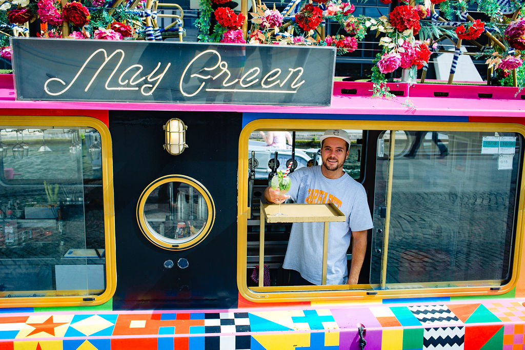 Colorful beverage cart with floral decor for outdoor events like weddings and festivals.