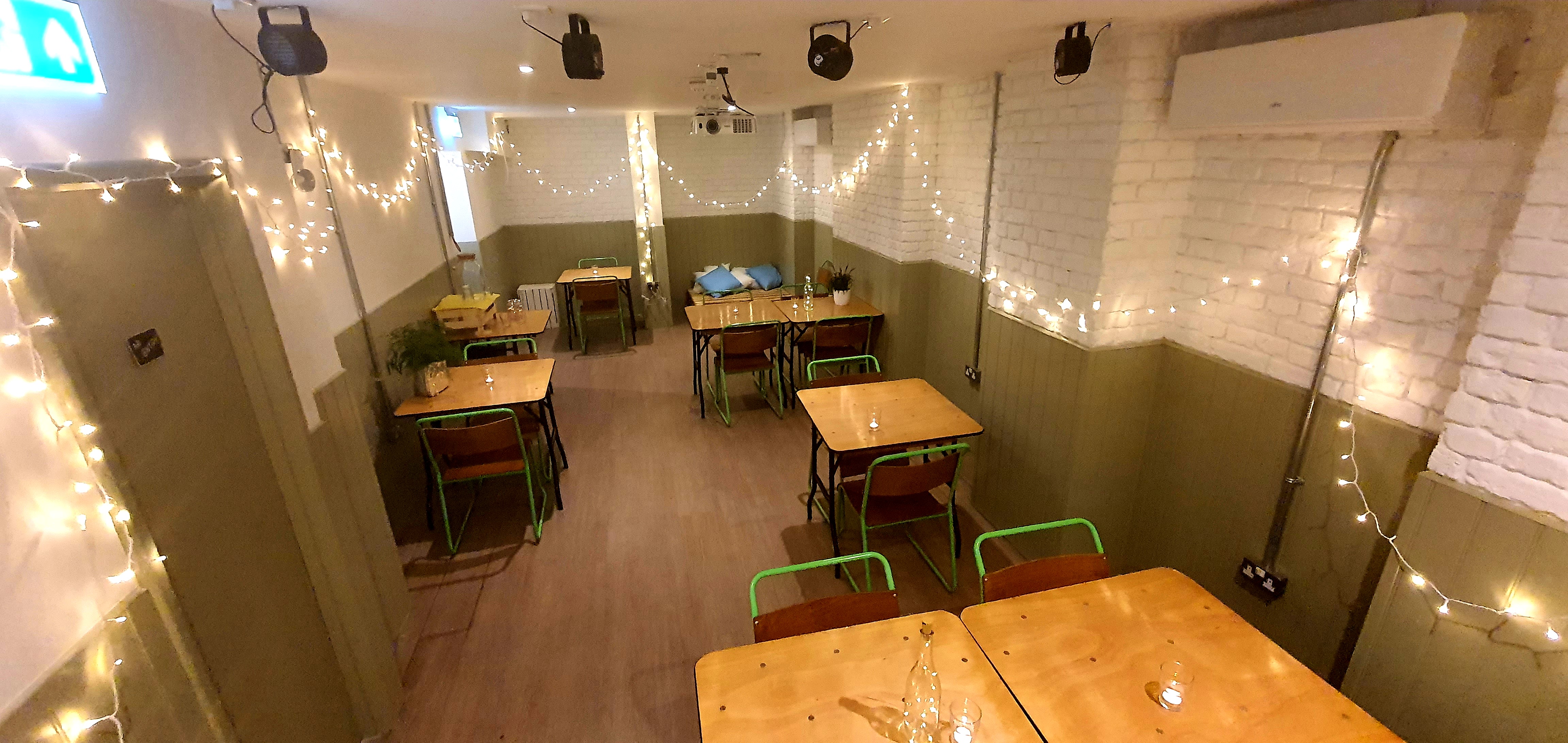 Cozy event space with string lights, perfect for intimate gatherings and workshops.