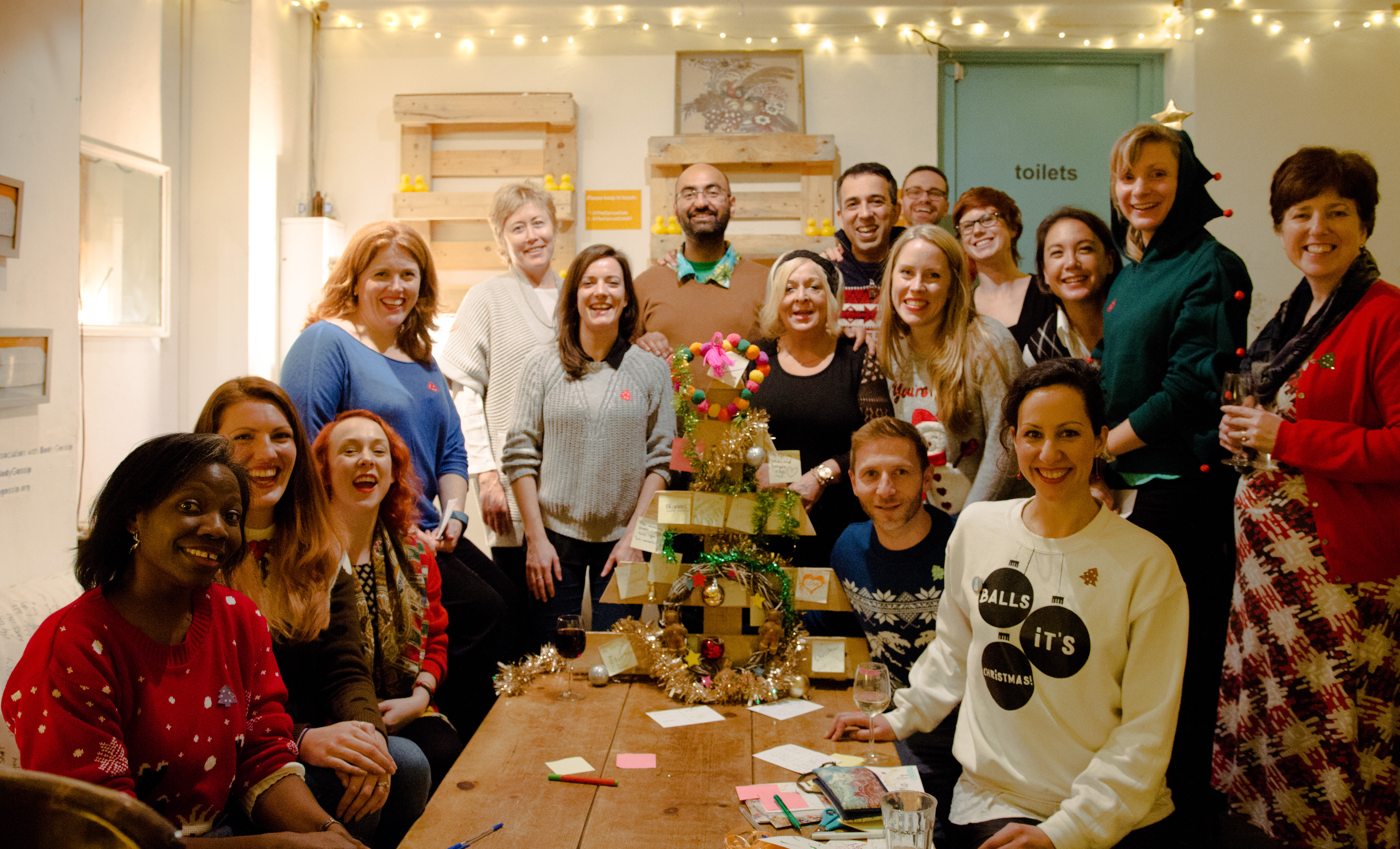 Vibrant professionals networking at The Canvas, festive team building event with warm lighting.