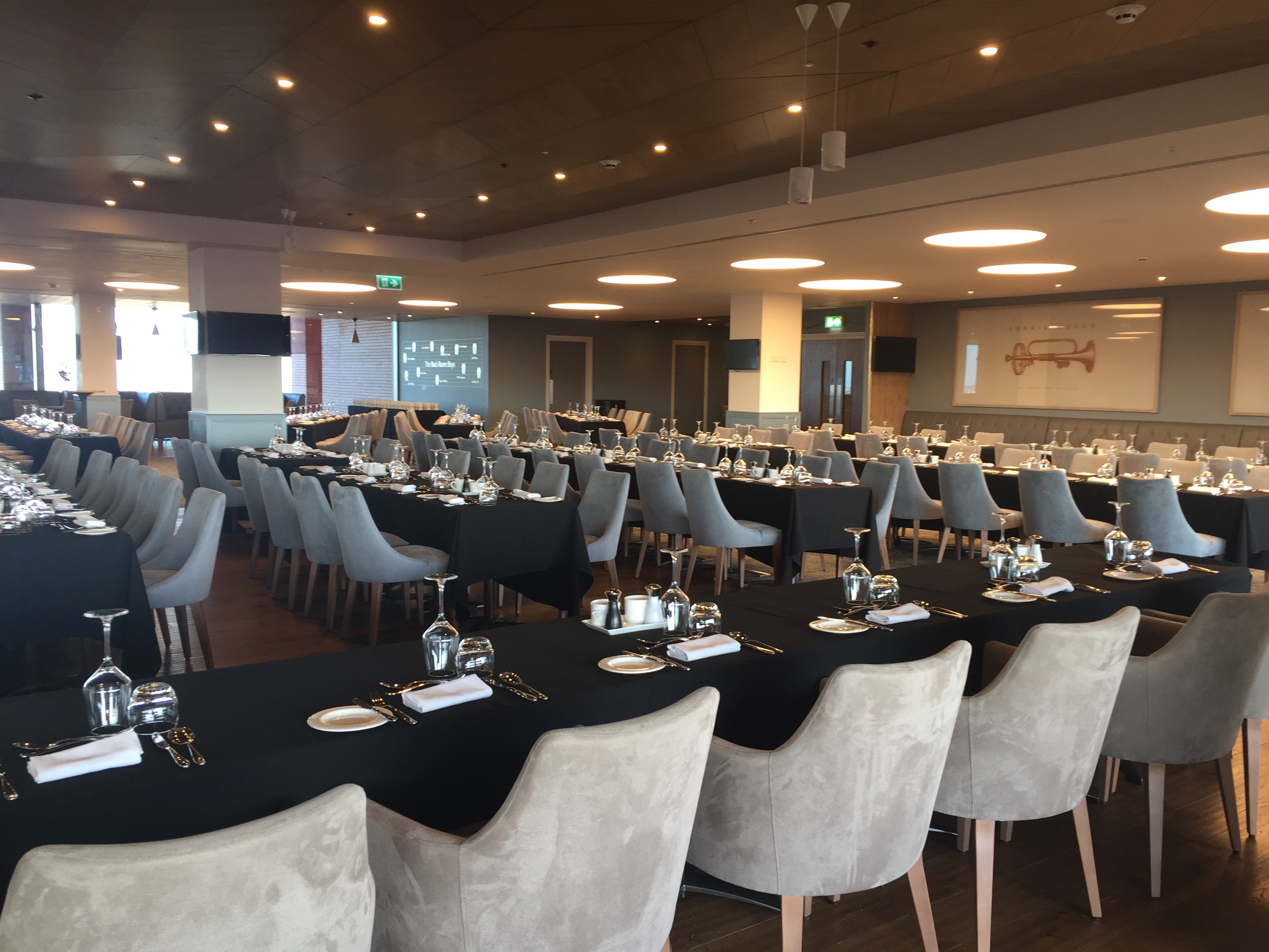 Elegant event space at Liverpool FC with modern tables for corporate meetings.