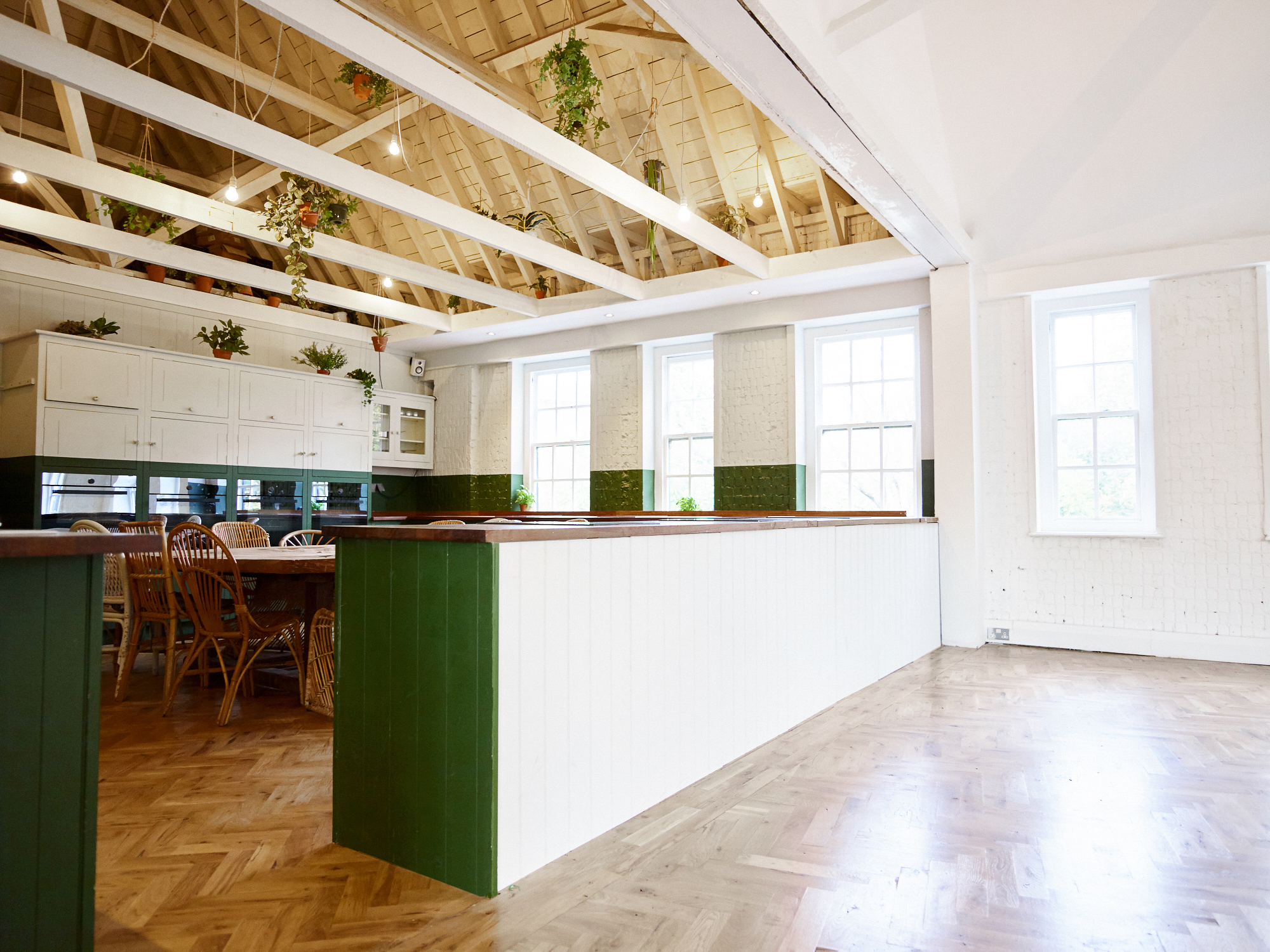 Bright event space with modern kitchen, ideal for workshops and networking events.