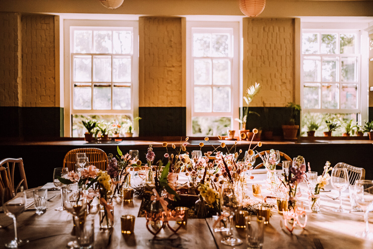 Elegant event space at B&H Kitchen with floral centerpieces and natural light.