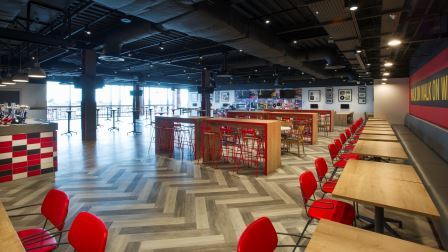Anfield Beat event space with vibrant red seating, perfect for networking and gatherings.