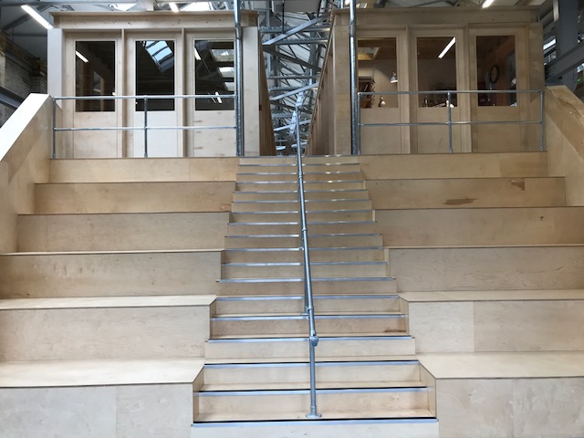 Modern Exhibition Hall in Craft Central with wooden steps for creative events.