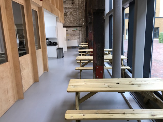 Modern Exhibition Hall with wooden tables, ideal for networking events and meetings.