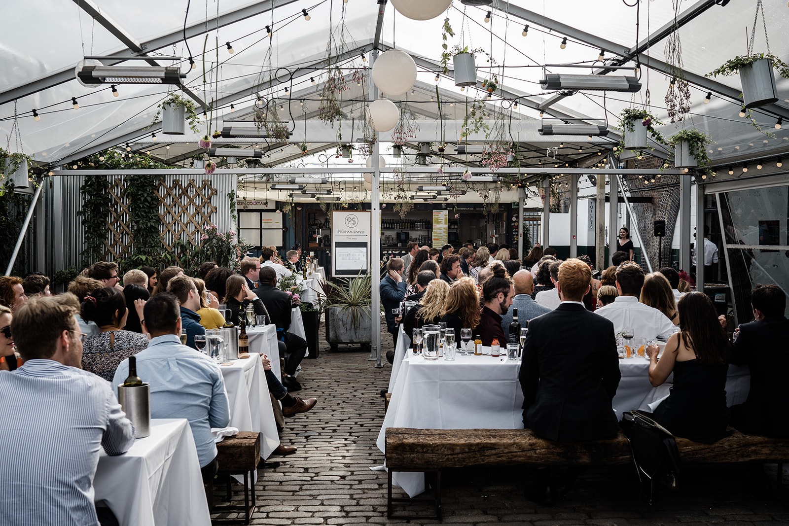 Elegant Palm House greenhouse event with styled tables for networking and presentations.