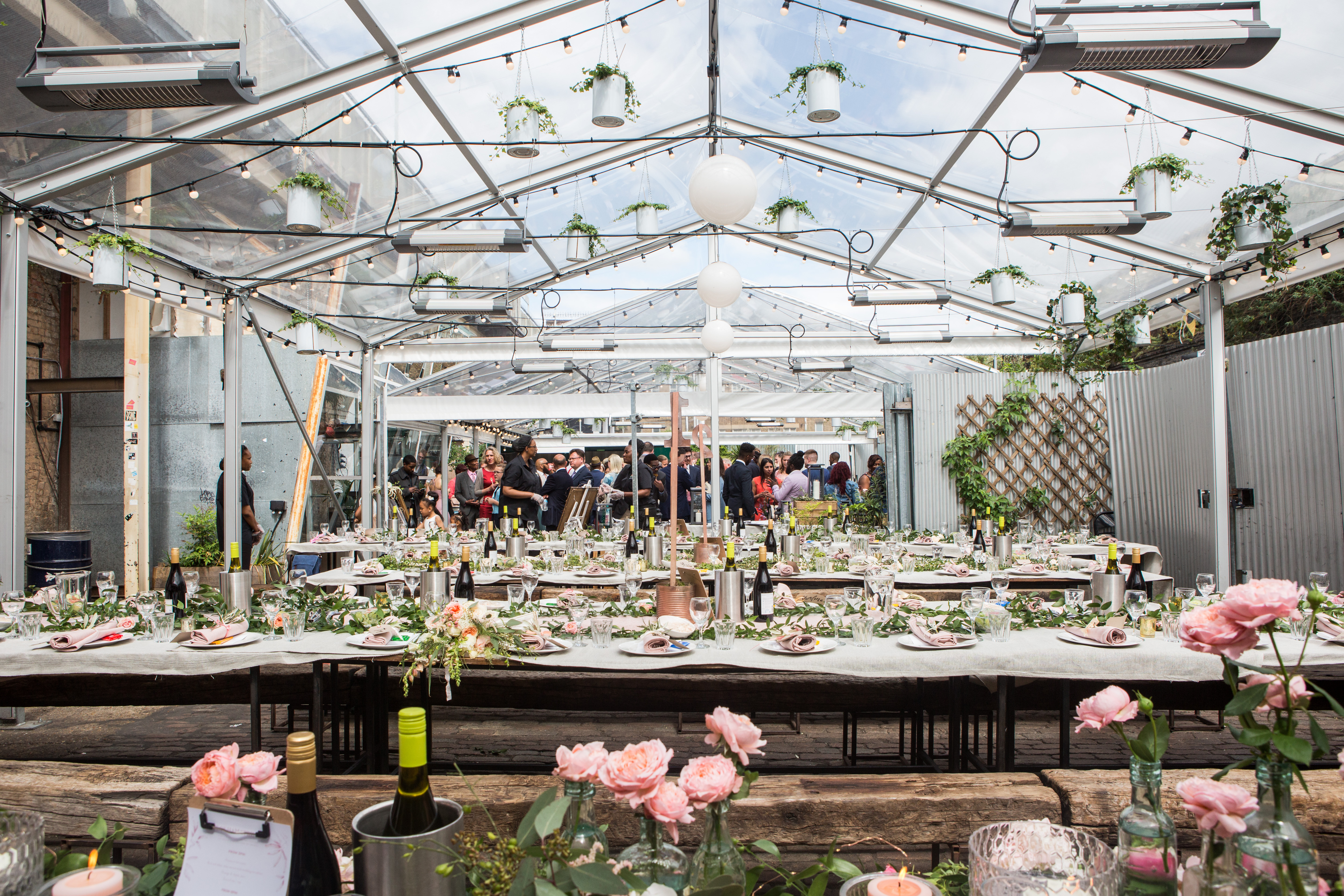 Elegant greenhouse event space with floral centerpieces for networking and celebrations.