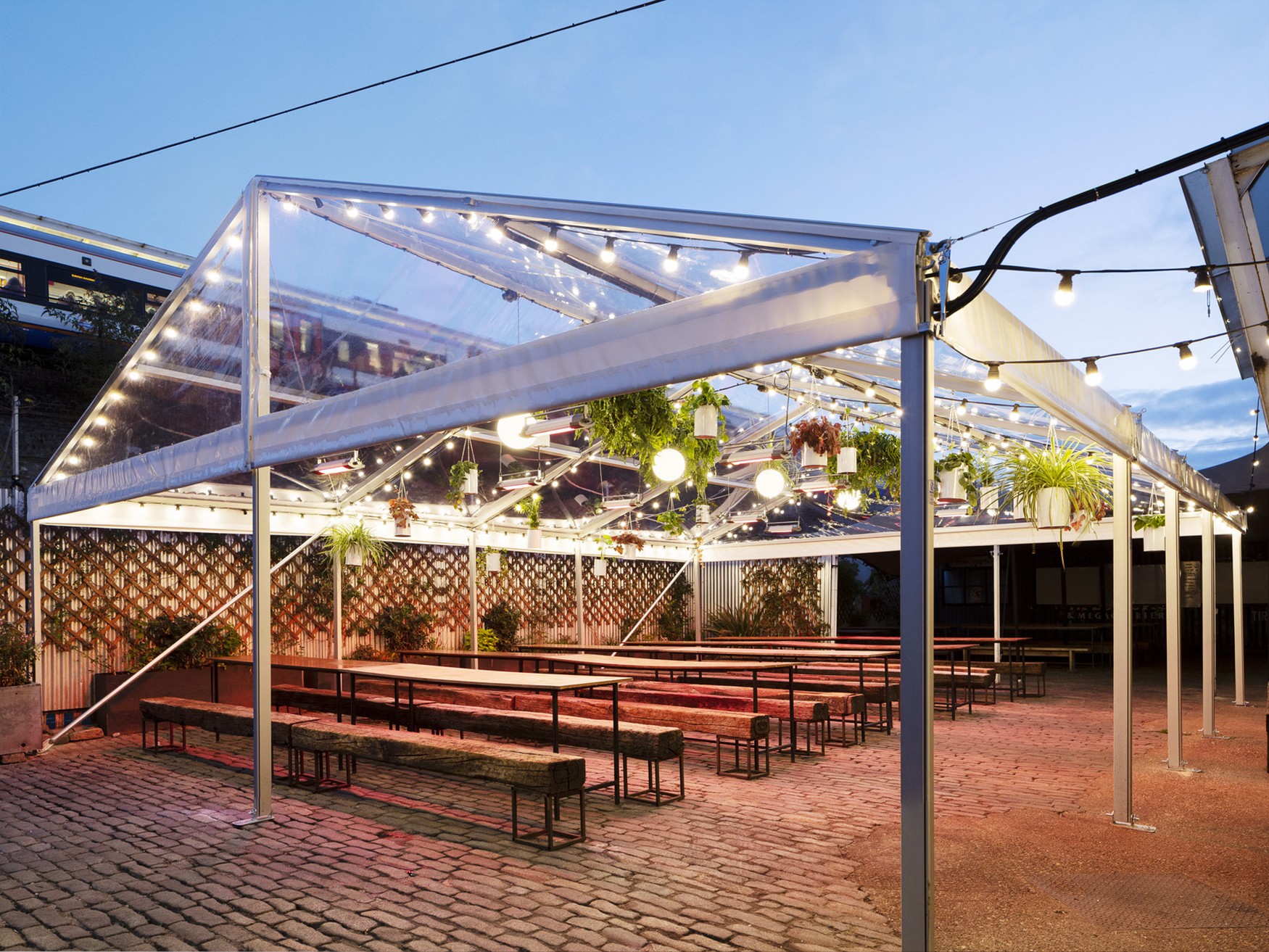 Outdoor event venue in Peckham Springs with illuminated clear tent for receptions.