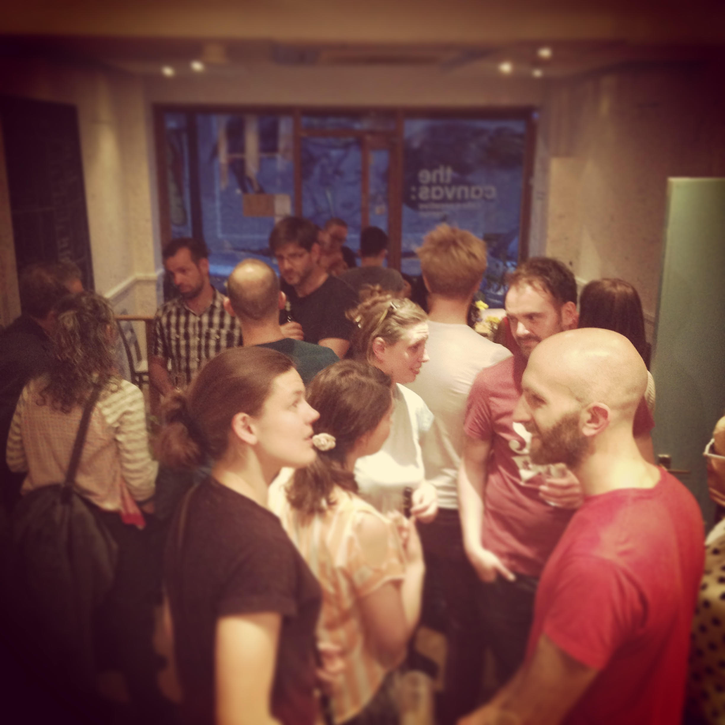 Networking event at Cafe in The Canvas, diverse attendees engaging in lively discussions.