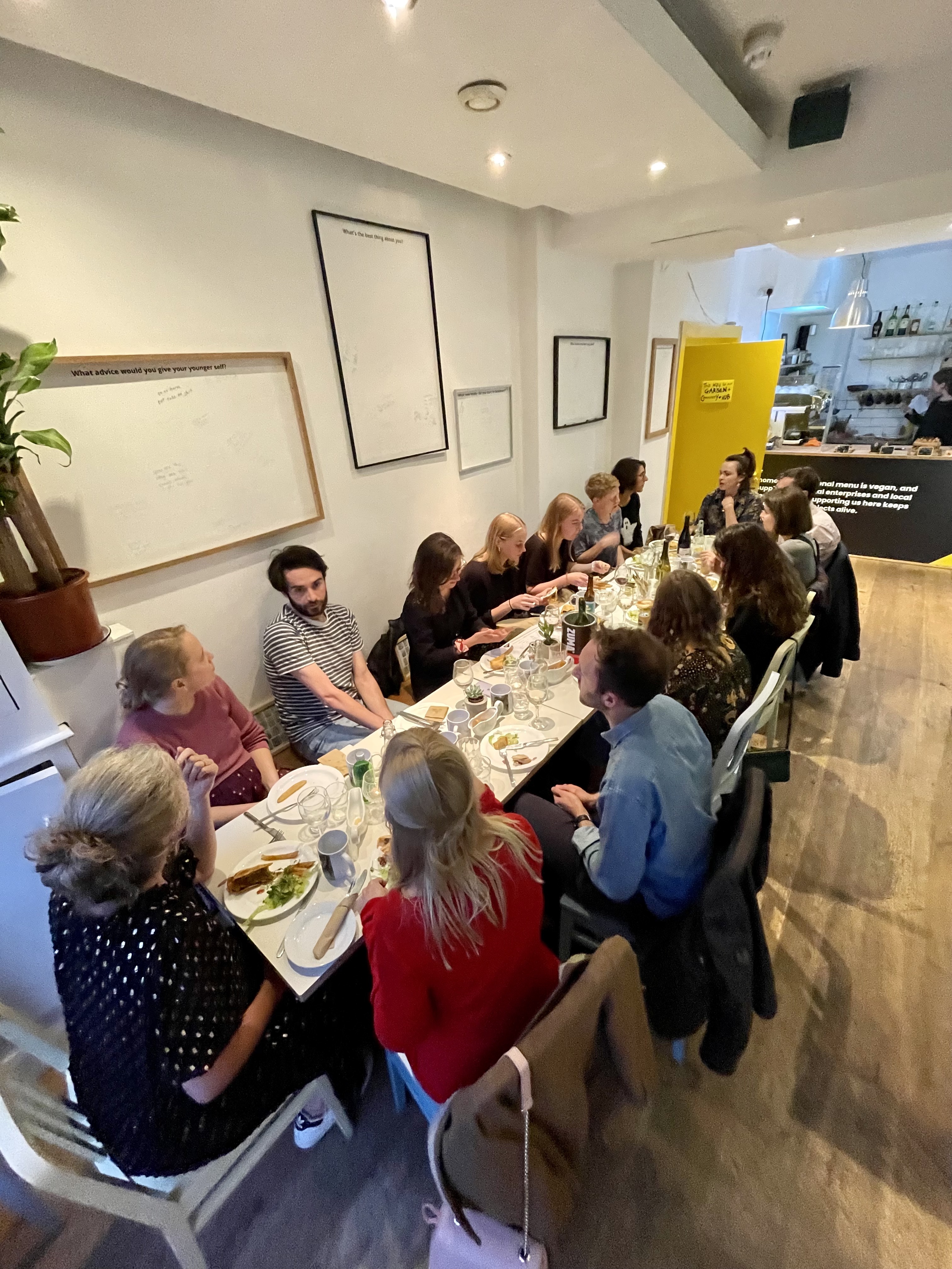 Long table in stylish cafe, ideal for creative networking and team-building events.