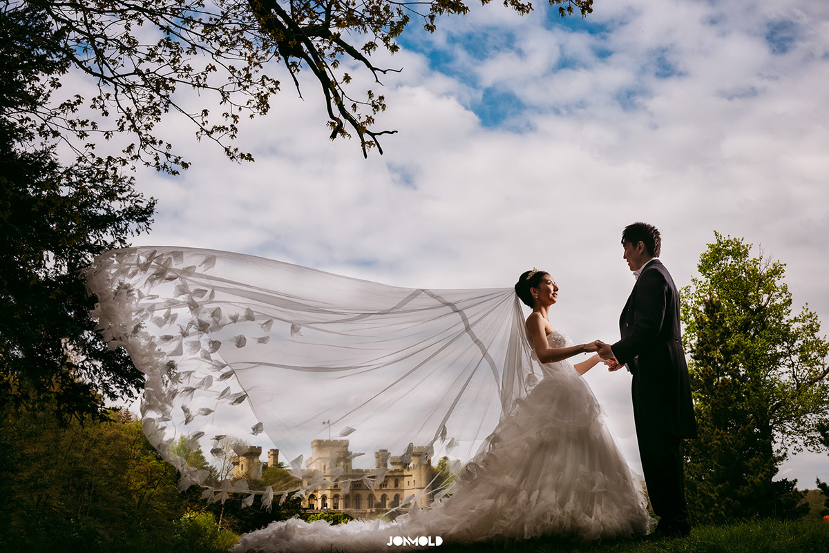 Couple with flowing veil at Eastnor Castle, perfect for romantic wedding photography.