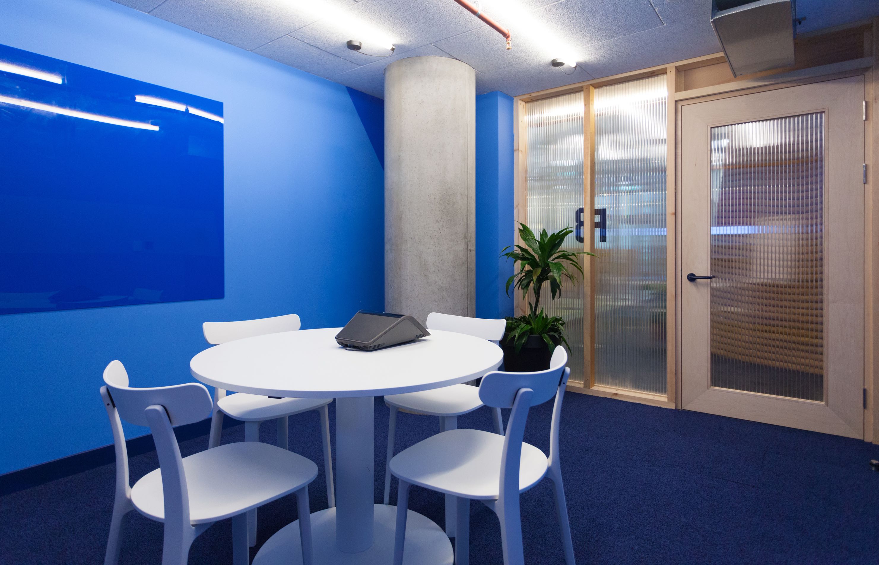 Modern F8 Meeting Room with round table, ideal for brainstorming and collaboration.