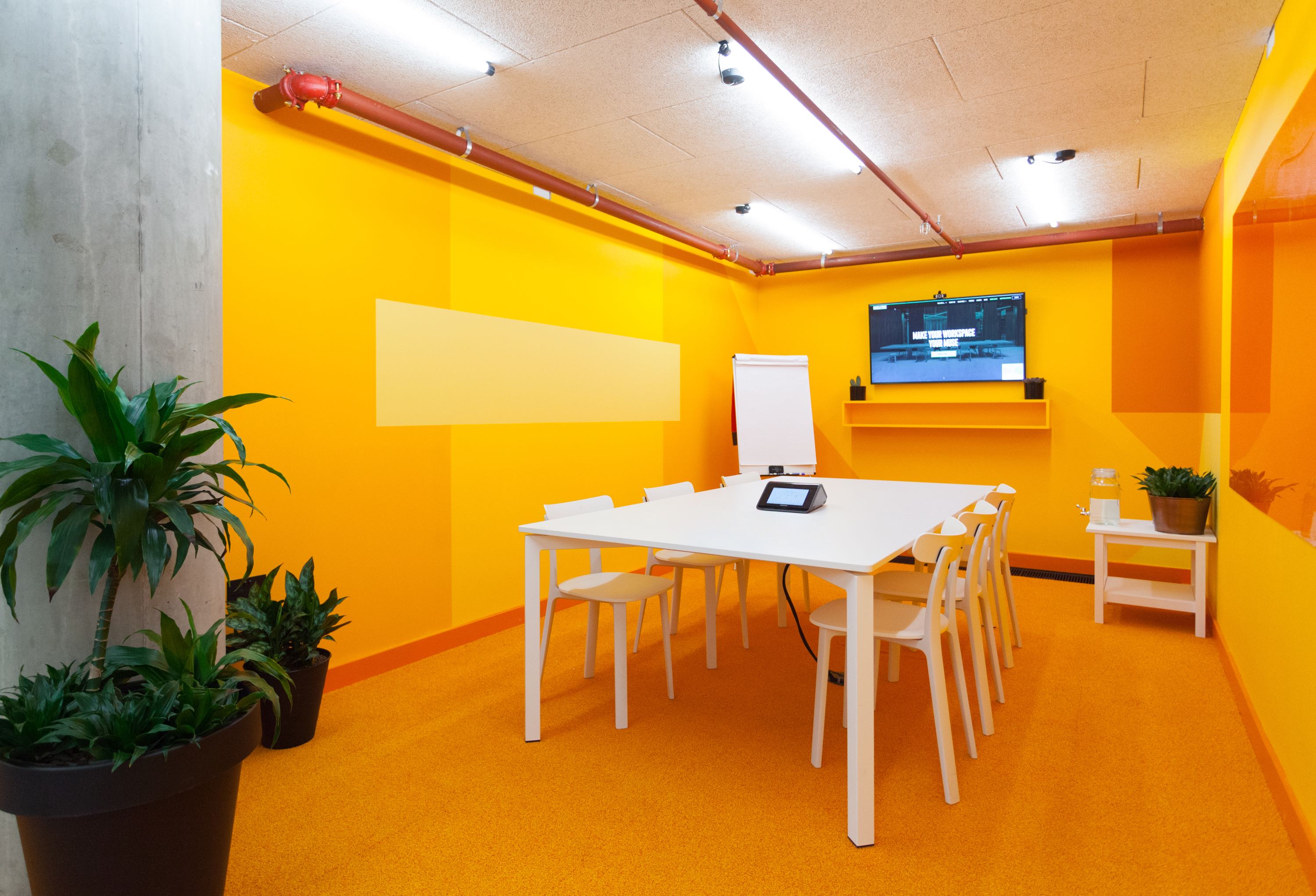 Vibrant meeting room with orange walls, ideal for creative brainstorming sessions.