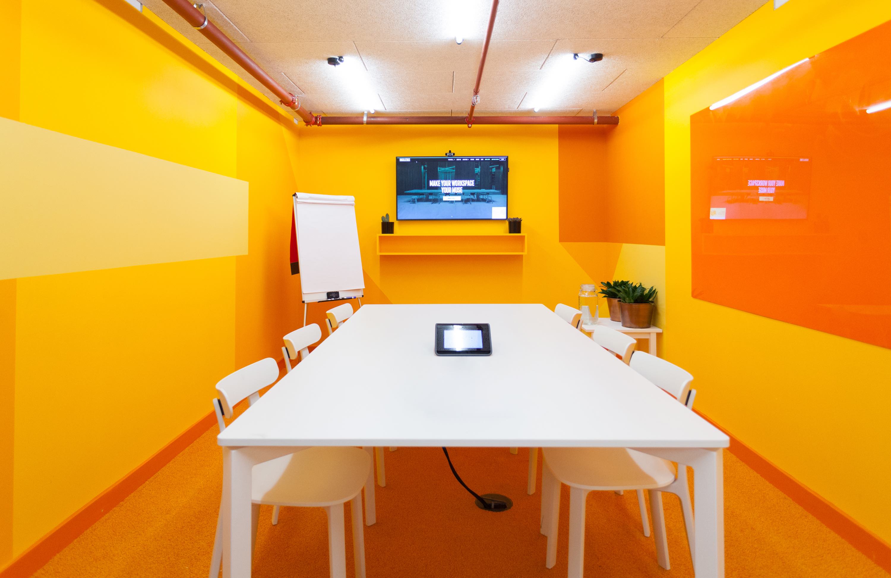 Modern meeting room with yellow walls, ideal for creative workshops and team gatherings.