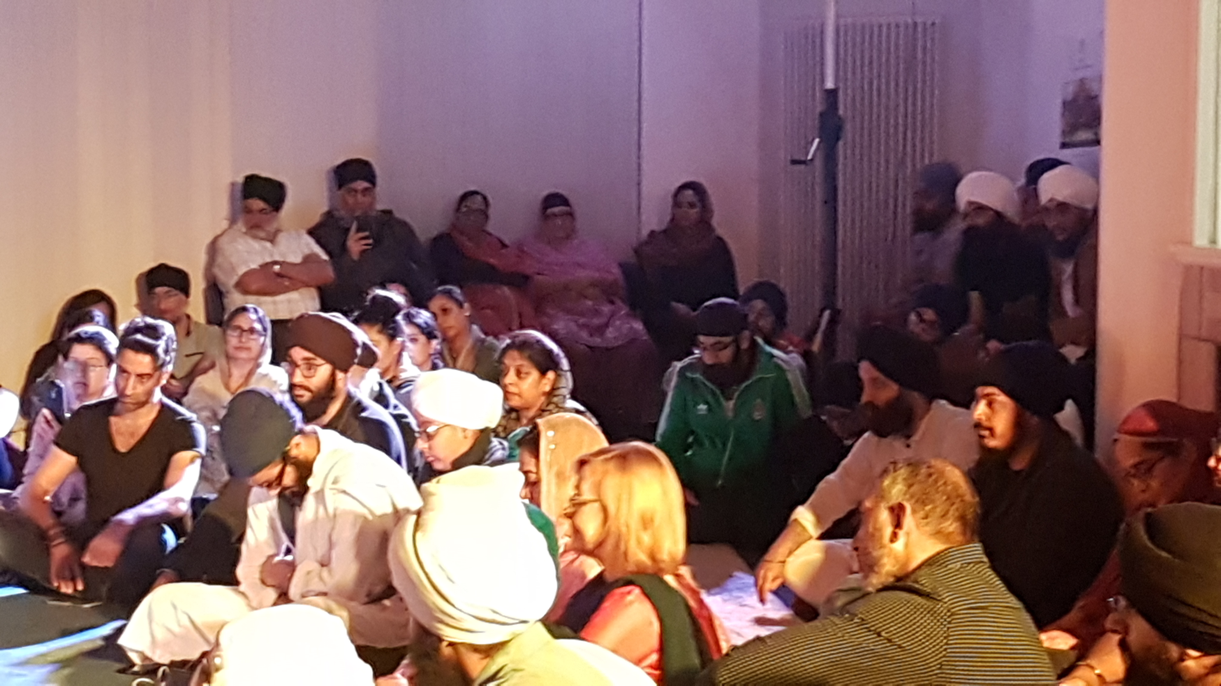 Diverse audience in Nishkam Centre seminar room for a cultural community gathering.