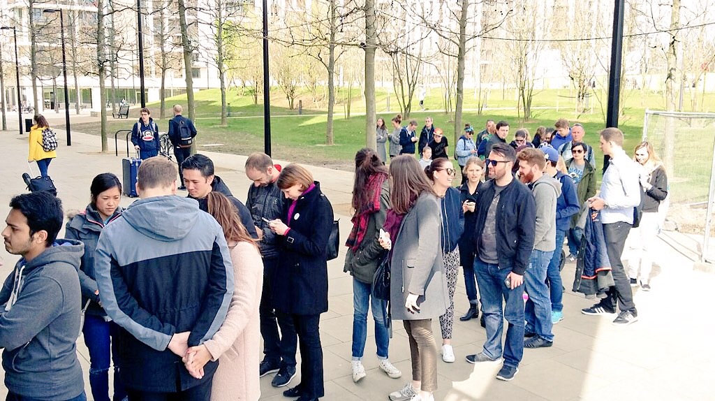 Diverse attendees in line at La Gelatiera gelato cafe for a casual event registration.