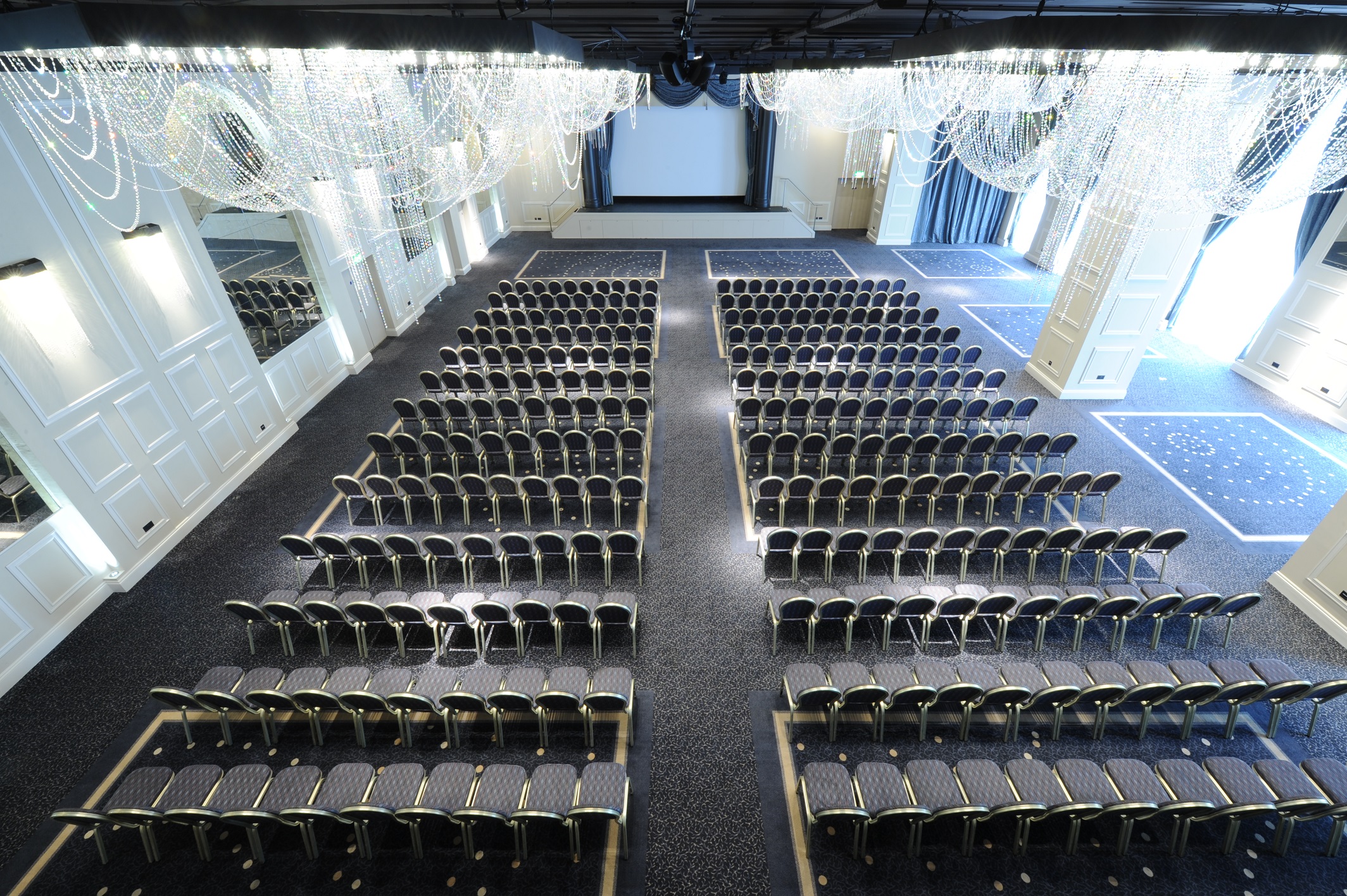 International Suite at Mercure Manchester, elegant conference space with chairs and screen.