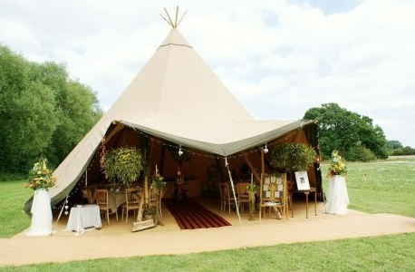 Elegant tented outdoor wedding venue at Roundoak Farm with floral decor.