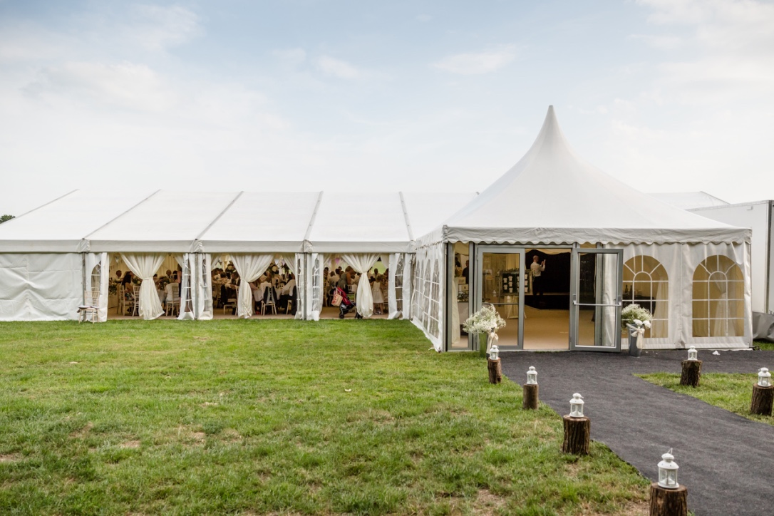 Spacious outdoor wedding tent at Roundoak Farm with large windows and green lawn.