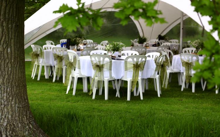 Elegant outdoor wedding setup at Roundoak Farm with white linens and green sashes.