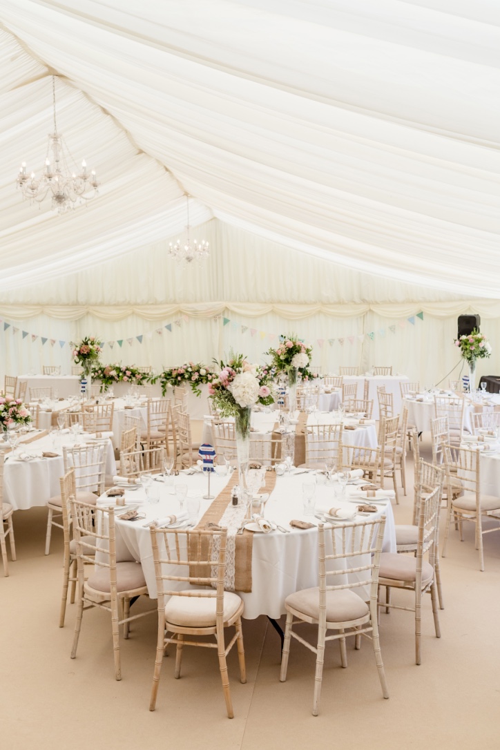 Elegant marquee setup for weddings at Roundoak Farm with floral decor and warm lighting.